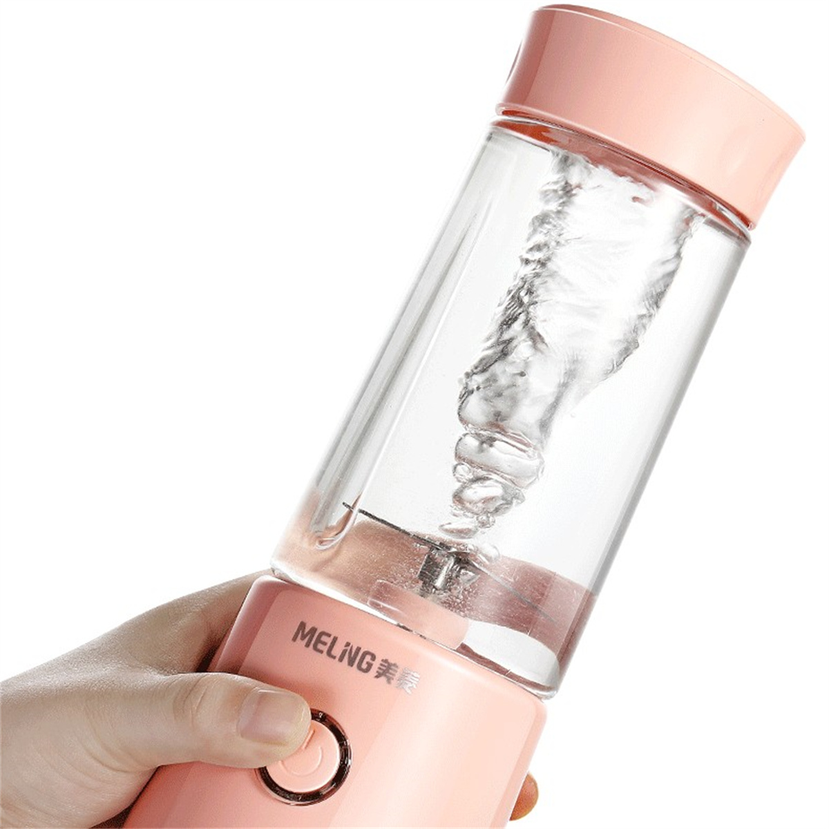 Licuadora personal rosa y transparente, el agua gira dentro. Mano sosteniendo la licuadora.