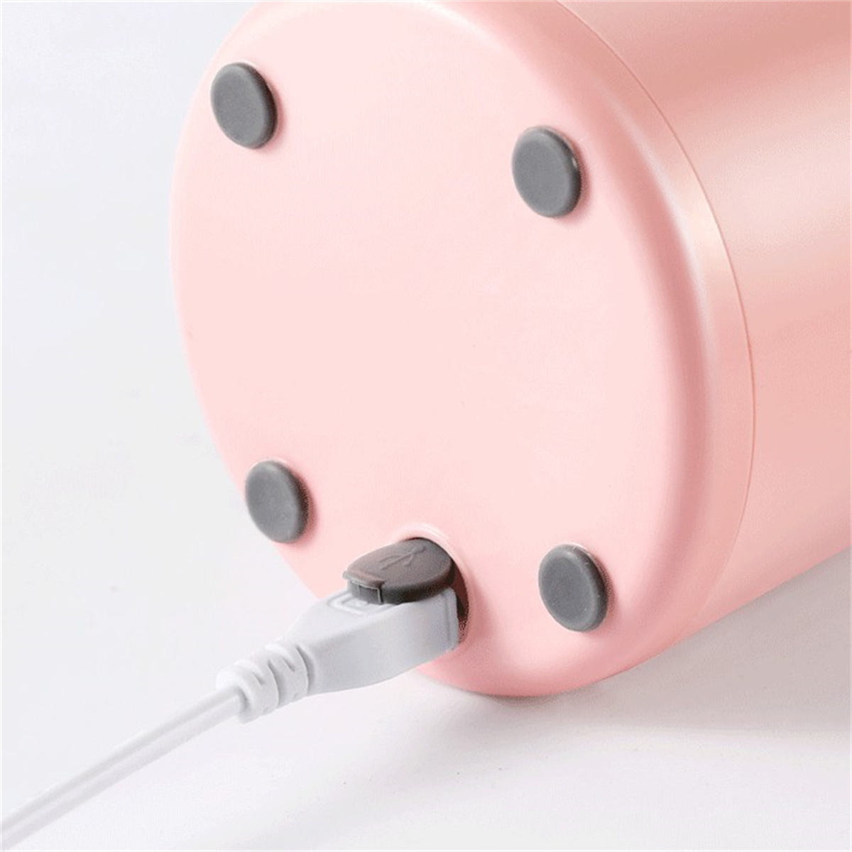 Base de licuadora rosa con cuatro pies grises y puerto de carga USB.