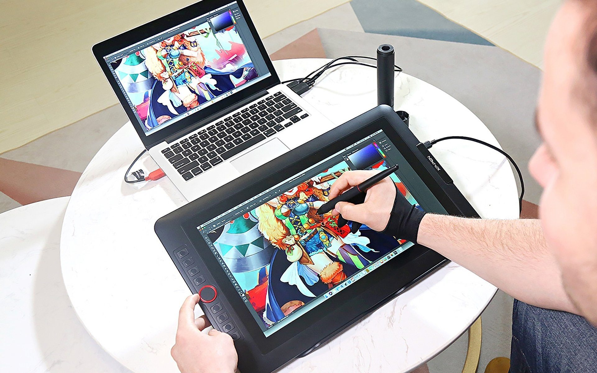 Person zeichnet auf einem Tablet, das mit einem Laptop verbunden ist.