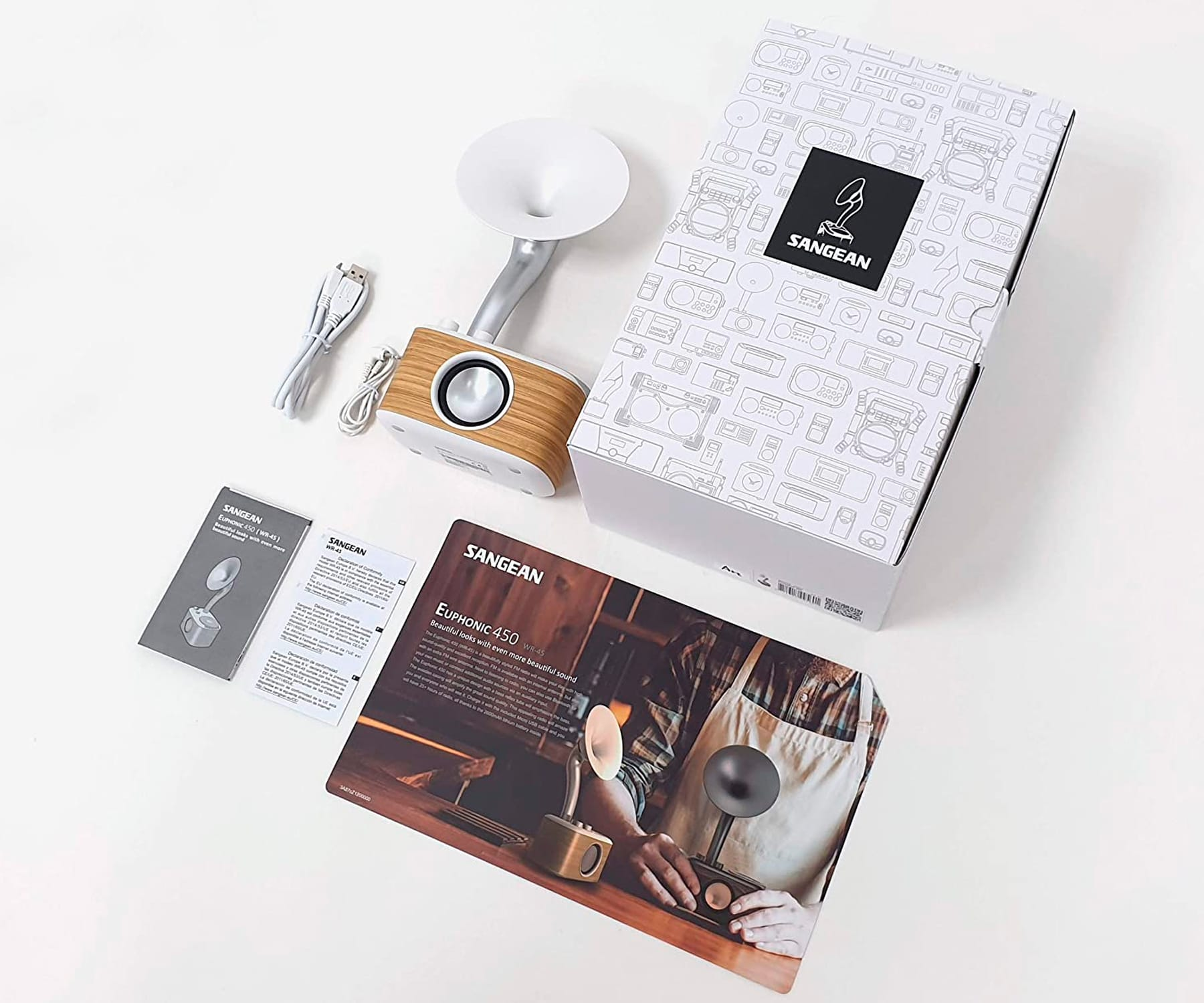 Urządzenie audio i akcesoria na białej powierzchni.