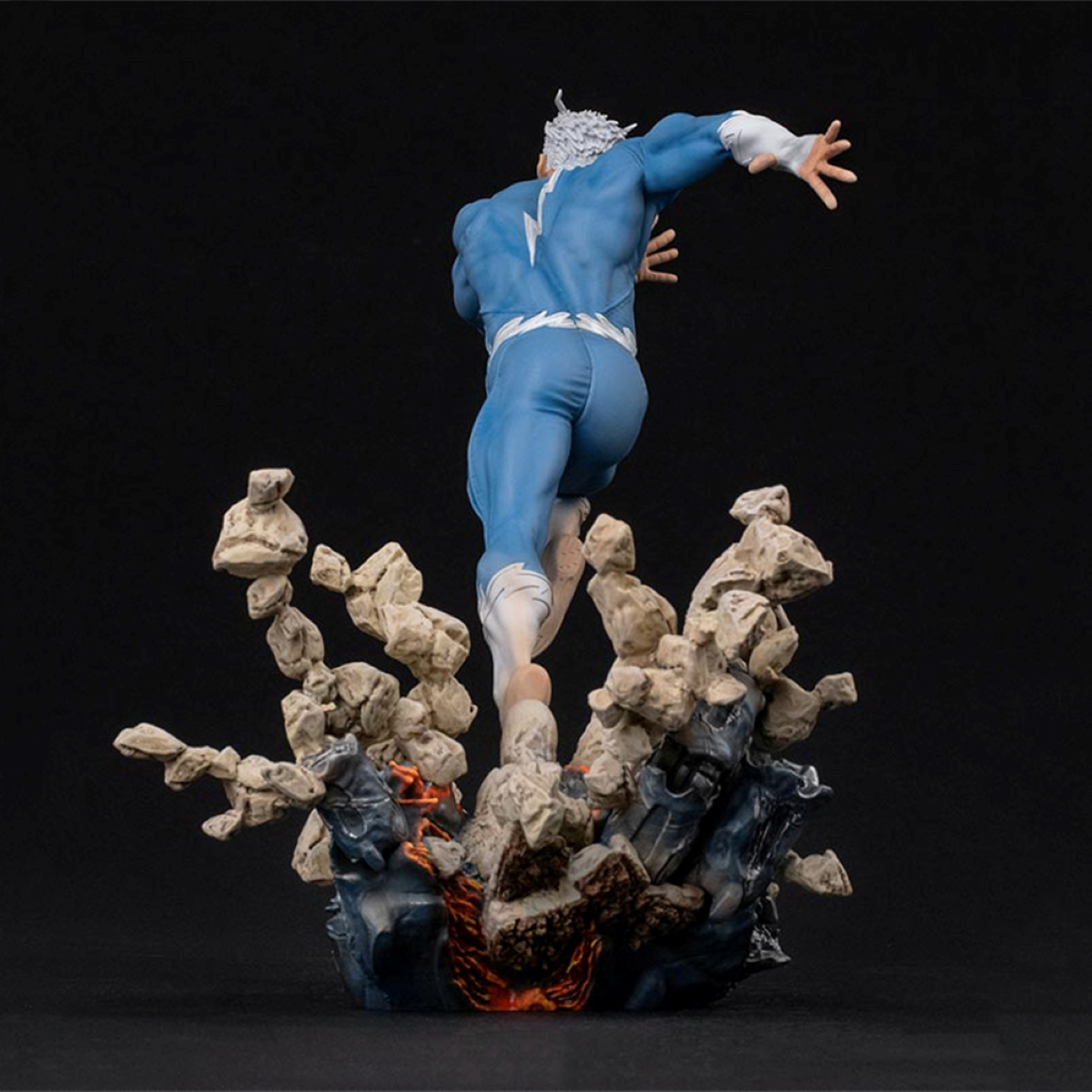 Quicksilver-Superheldenstatue, die von einem felsigen Sockel springt.