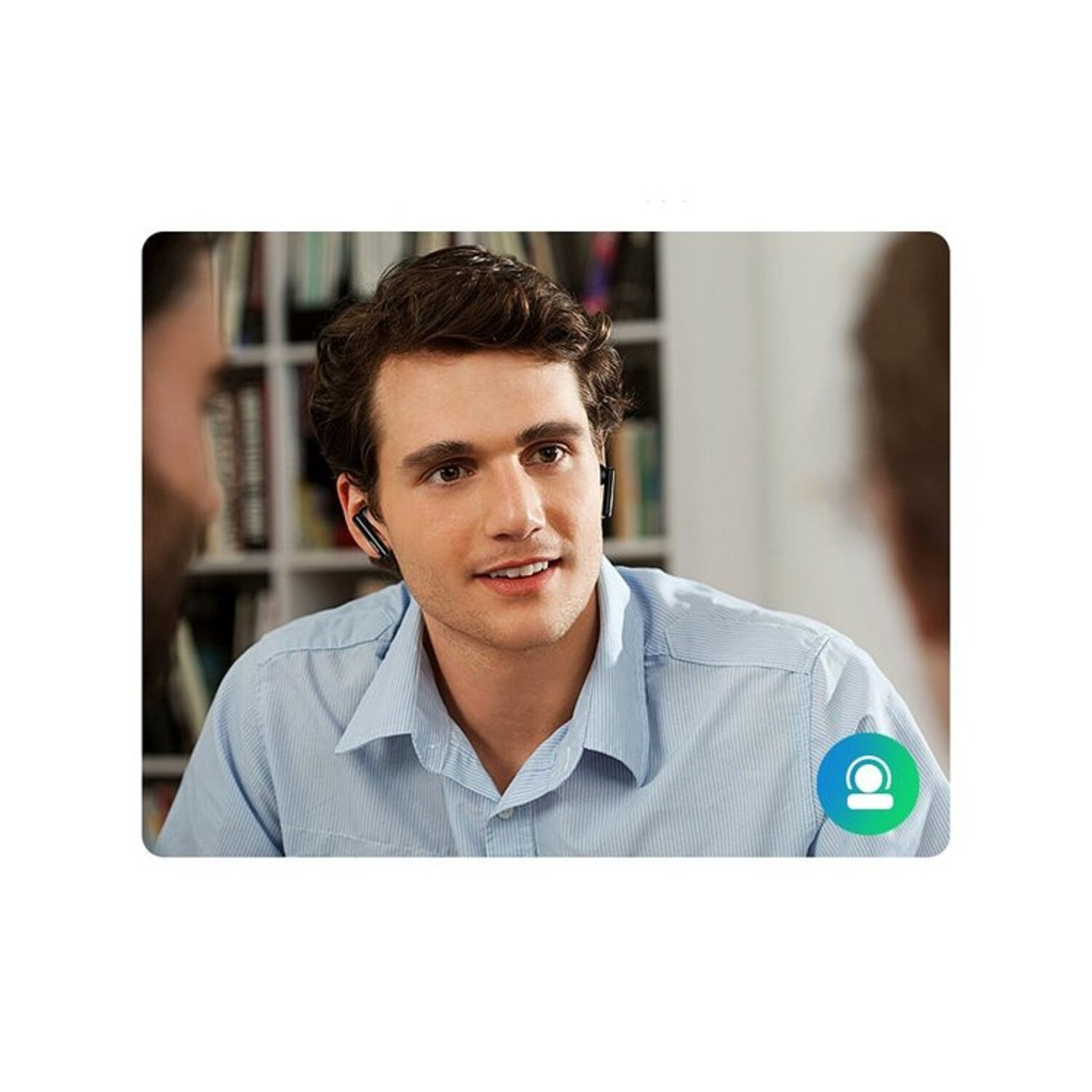 Ein Mann mit Ohrhörern lächelt und blickt nach rechts. Zwei weitere Männer im Hintergrund.
