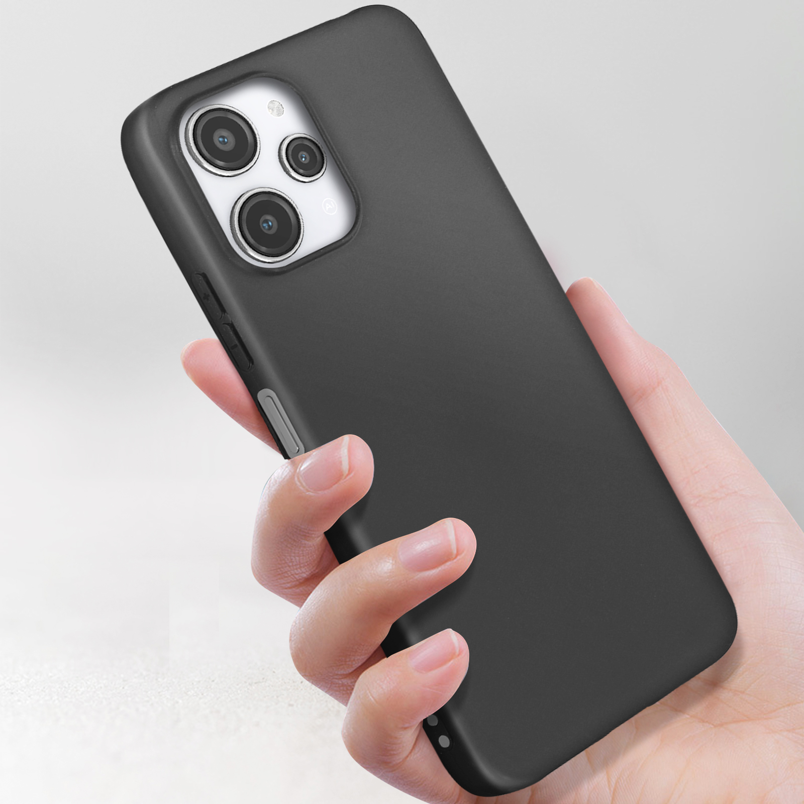 La mano di una persona che tiene un telefono nero con tre fotocamere. La custodia è nera.
