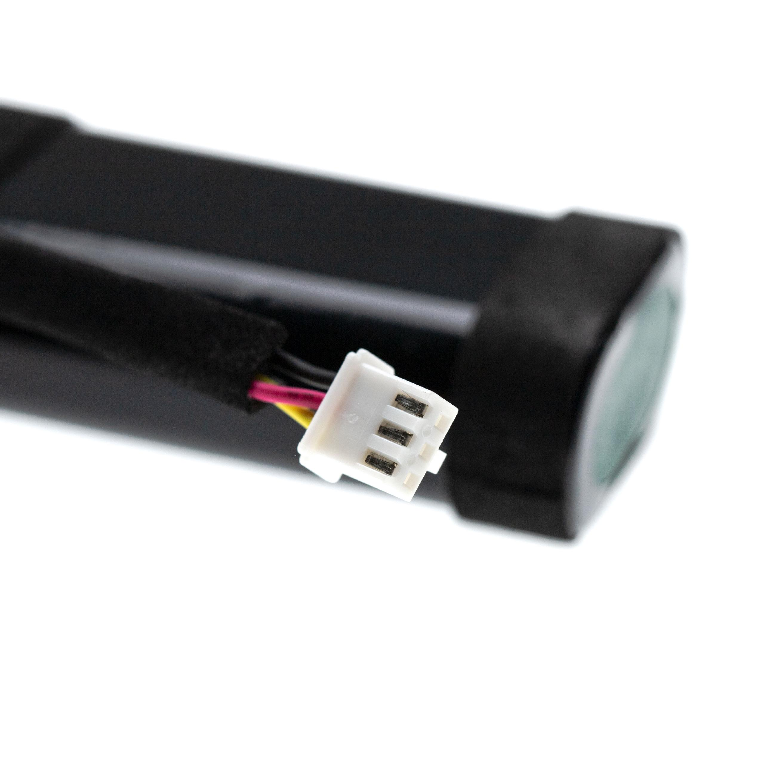 Nahaufnahme eines schwarzen Akkus mit weißem Stecker und farbigen Drähten. Ein grünes Element sichtbar.