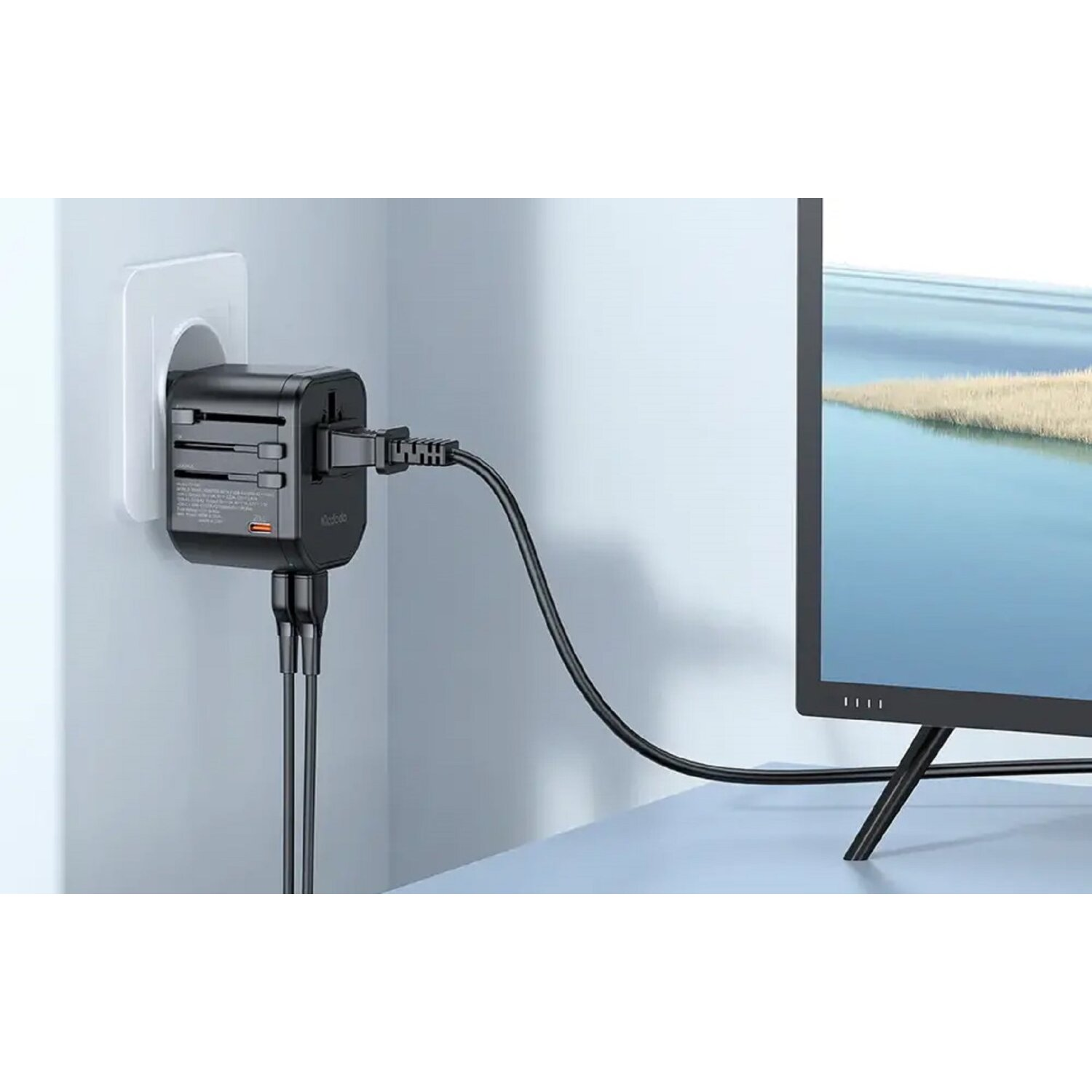 Schwarzer Adapter an der Wand, Kabel mit Fernseher verbunden.