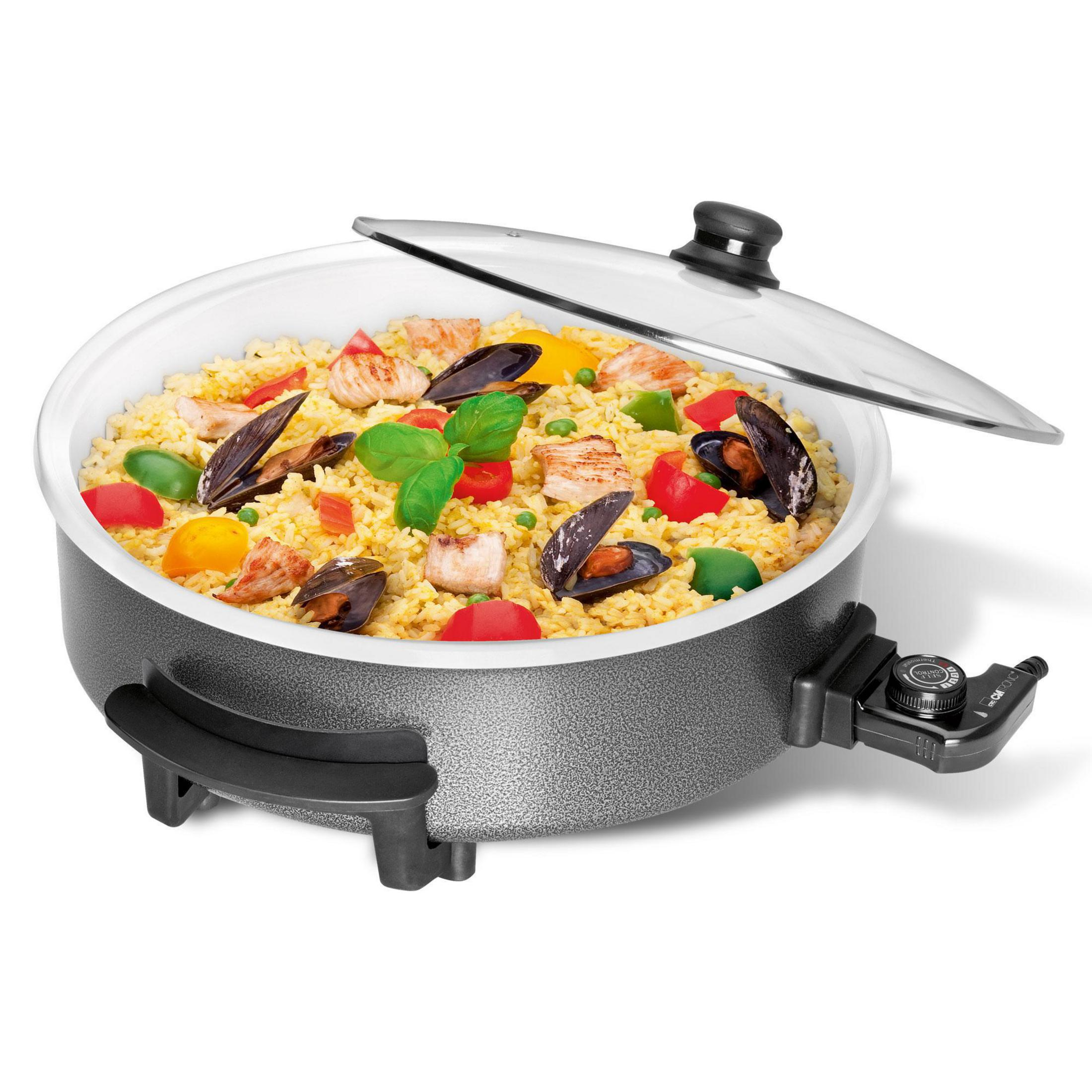 Elektryczna patelnia do paelli z jedzeniem i pokrywką. Białe tło.