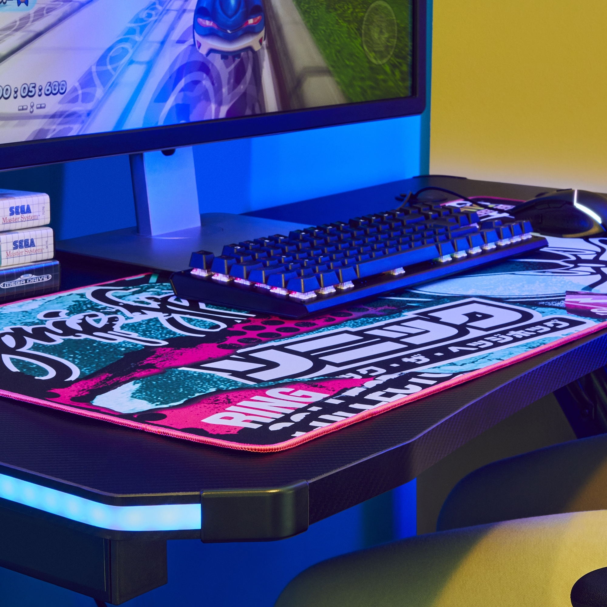 Configuración de juego con teclado y ratón en un escritorio, con un monitor que muestra un juego.