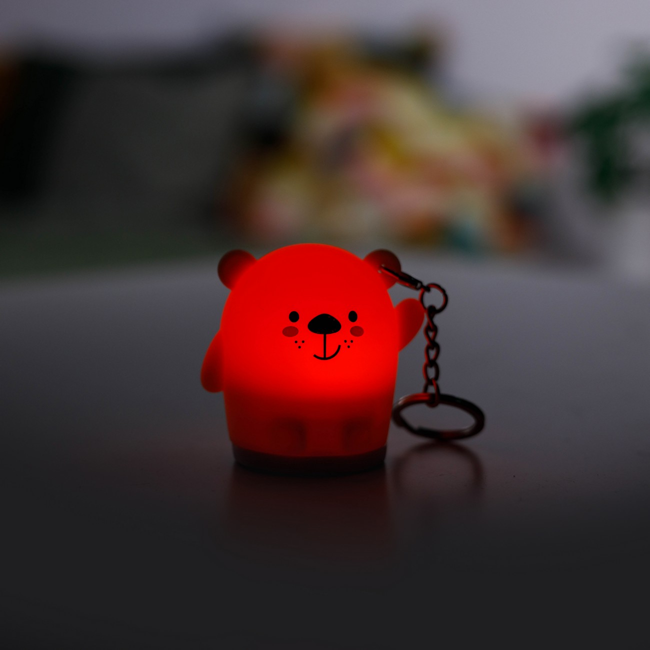 Luz de noche roja con forma de oso con llavero, brillando en la oscuridad.