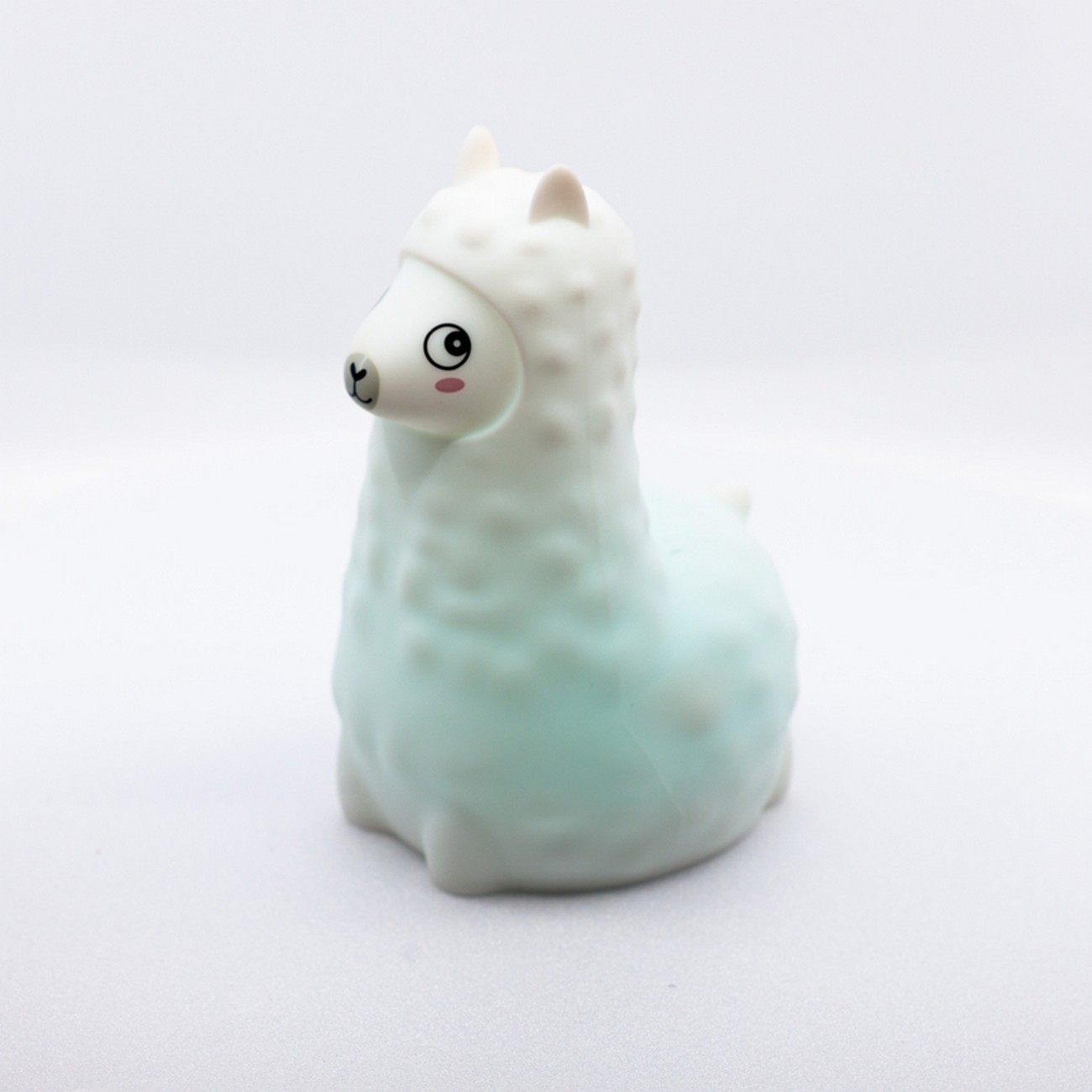 Una figura de llama blanca y celeste con una cara linda, sobre un fondo blanco.