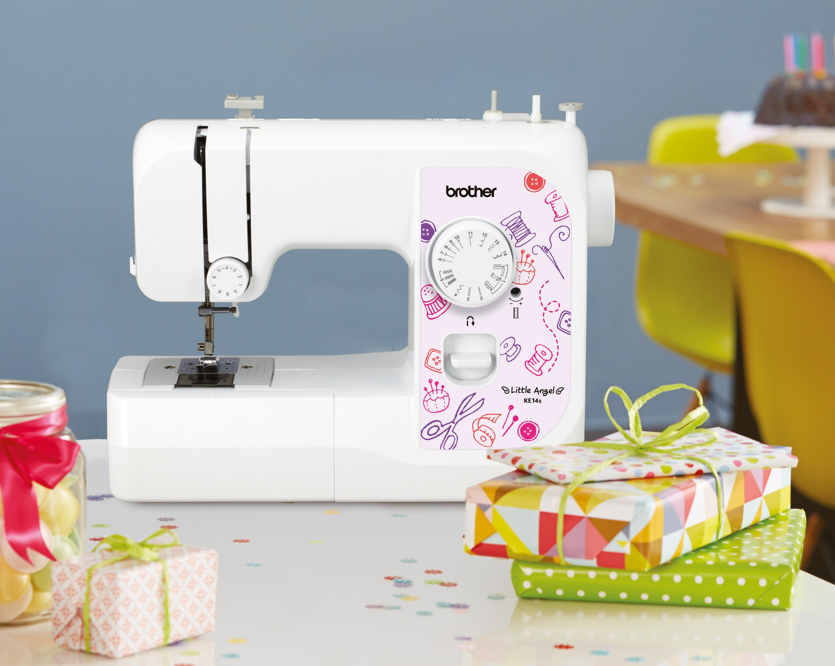 Biała maszyna do szycia z kolorowym wzorem. W tle prezenty i ciasto.