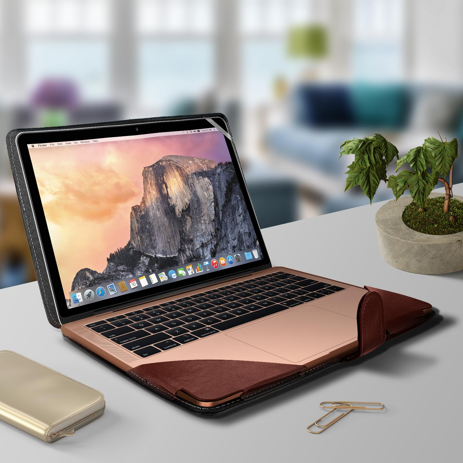 Laptop in custodia, aperto, che mostra lo schermo, con portafoglio e graffetta su una scrivania.