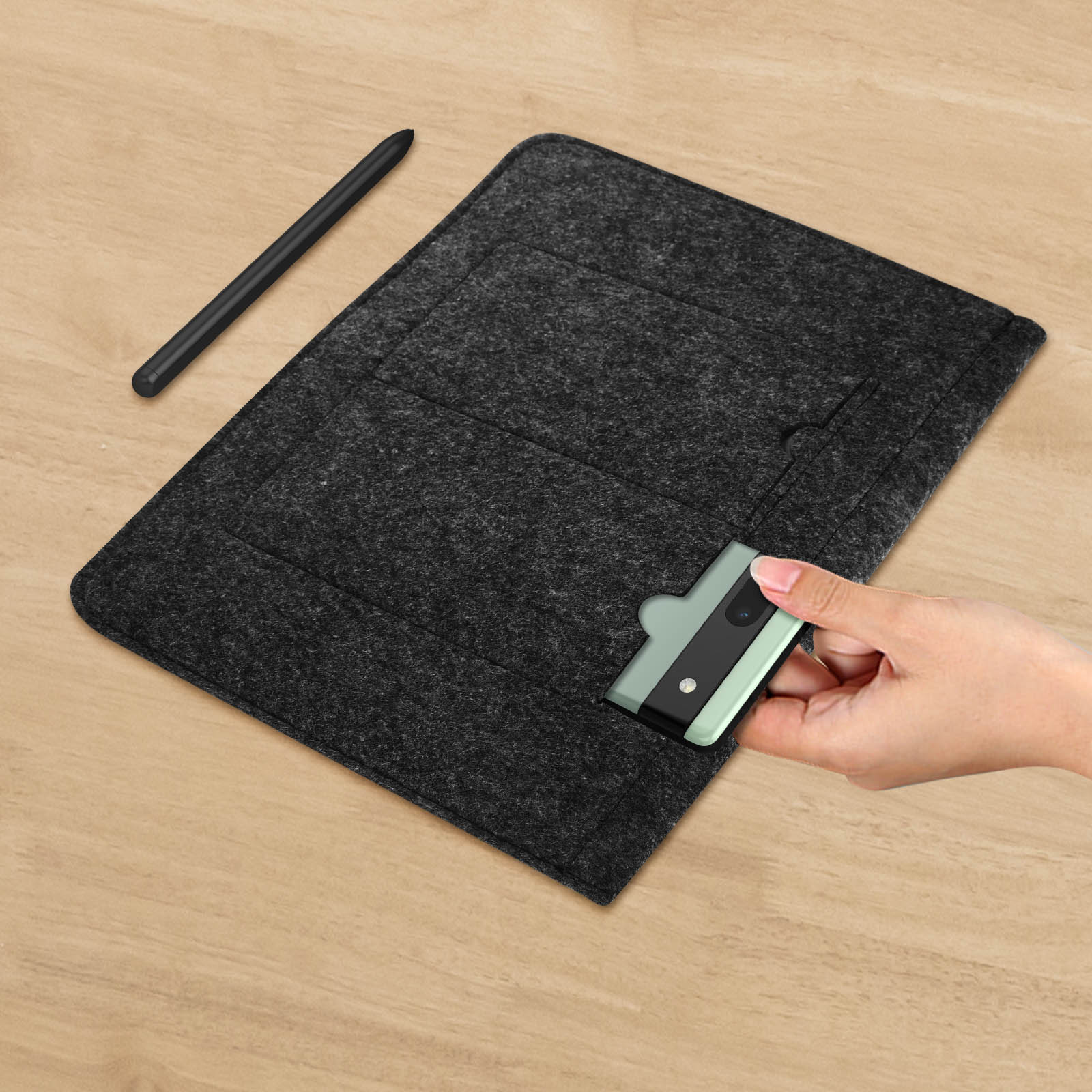 Custodia per tablet in feltro grigio scuro con uno stilo e un lettore di schede verde menta su un tavolo di legno.