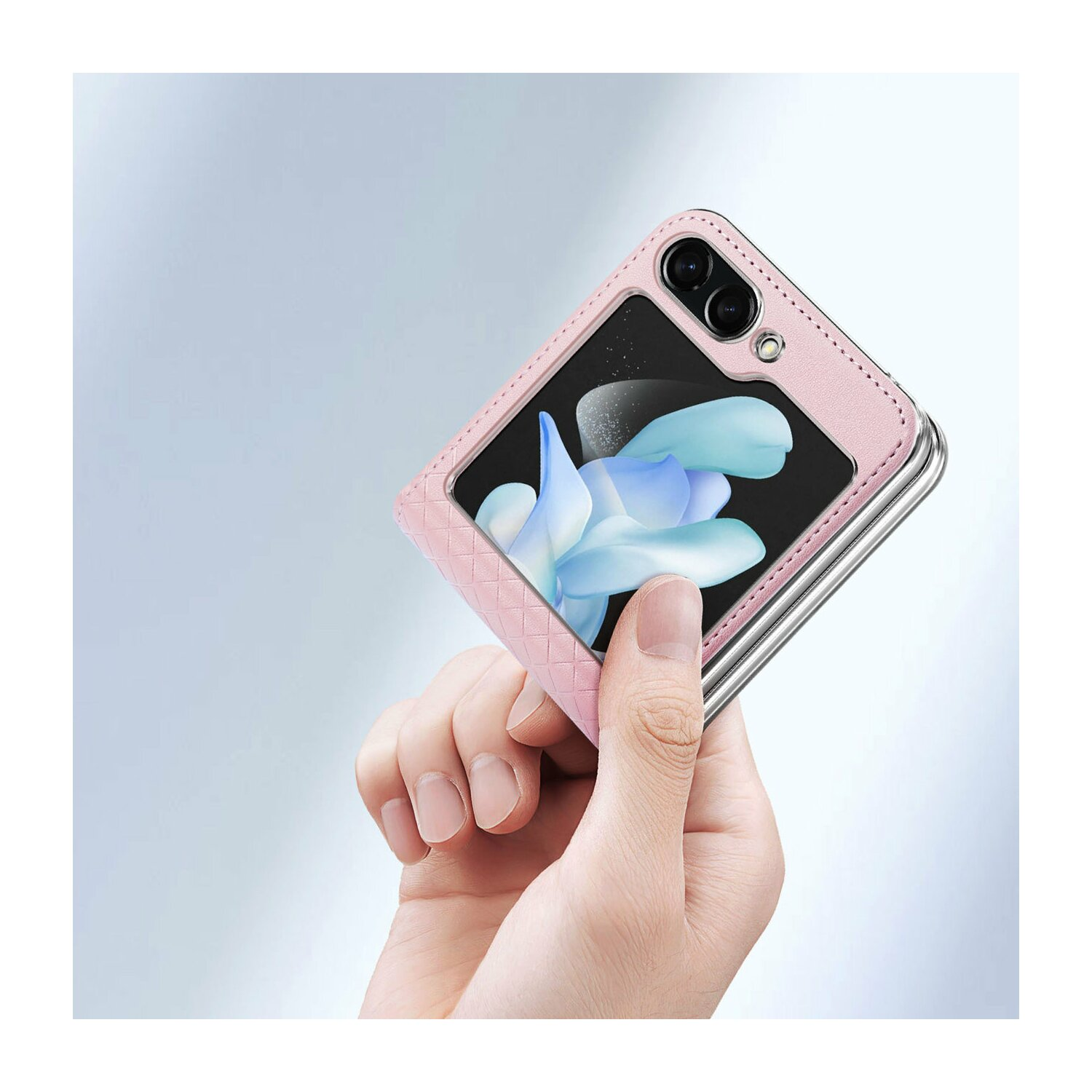 Eine rosa Handyhülle, aufgeklappt, mit einem Telefon darin, in einer Hand. Der Hintergrund ist hellblau.