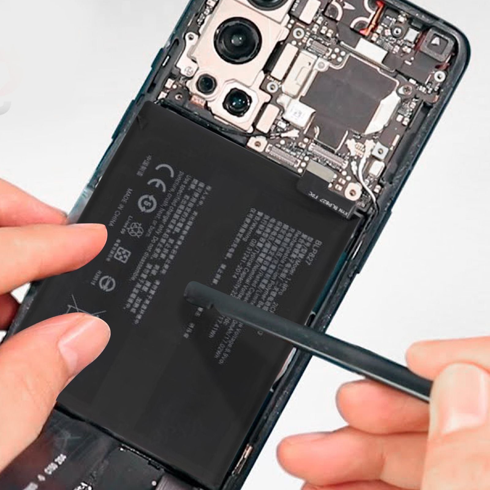 Ein Telefonakku wird aus einem Telefon entfernt. Hände und Werkzeuge sind sichtbar.