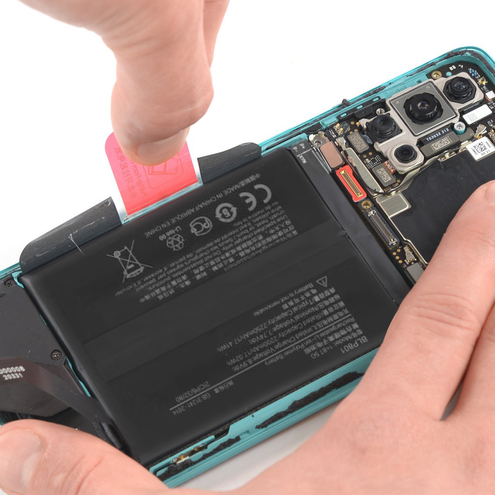Interne Komponenten eines Telefons, die mit Werkzeugen bearbeitet werden. Batterie ist sichtbar.