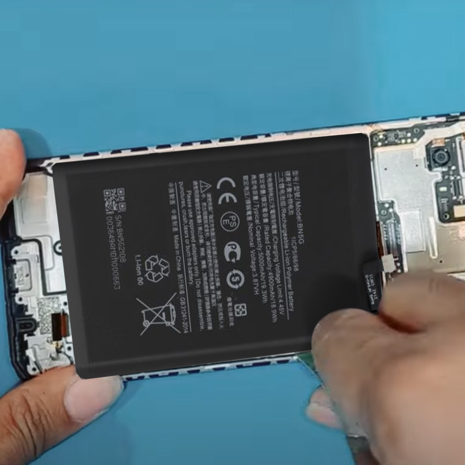 Eine Person repariert ein Telefon und zeigt den Akku.