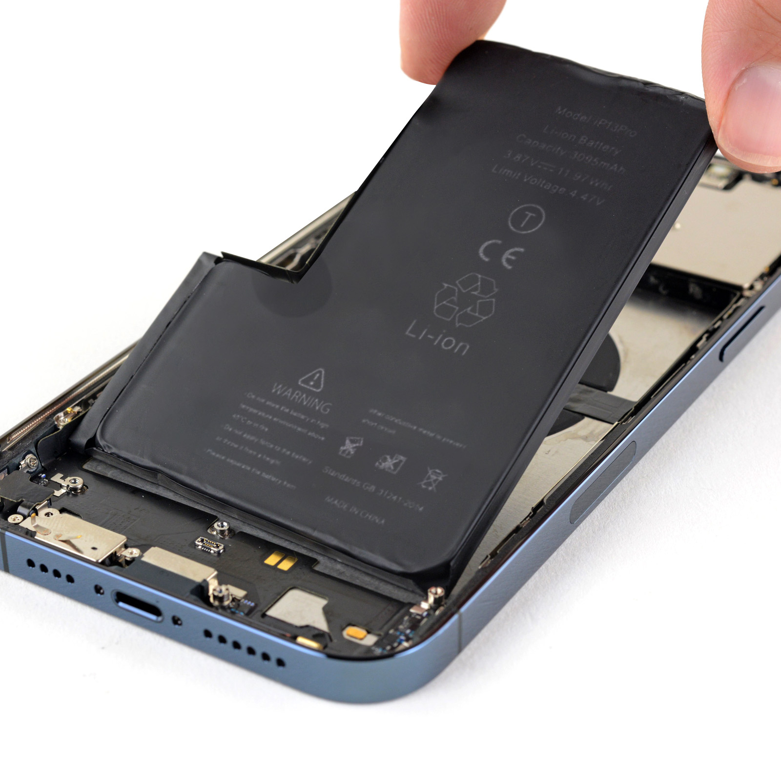 Hand, die einen Telefonakku über dem Telefonrahmen hält. Der Akku ist schwarz.