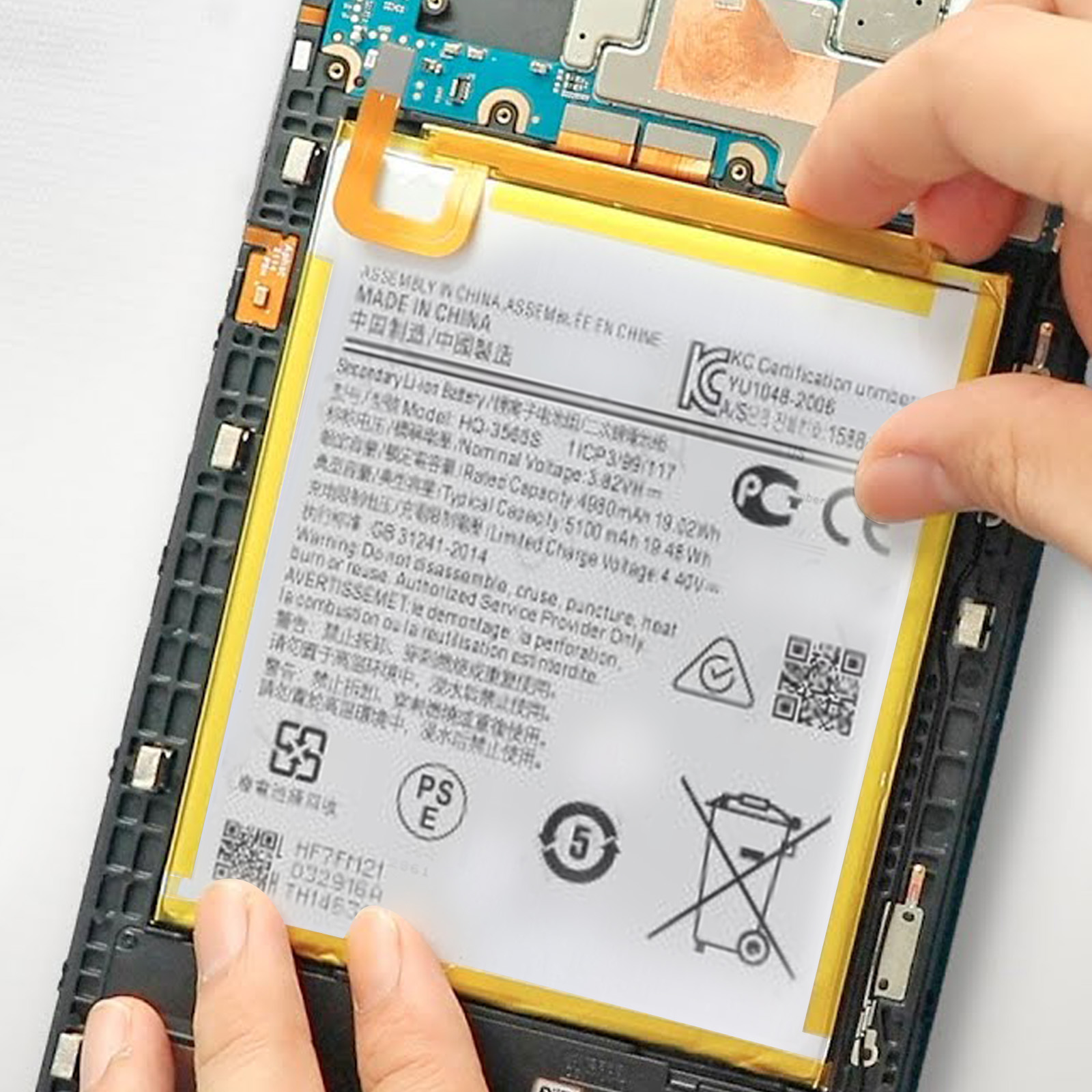 Hände halten ein Telefon, dessen Rückseite geöffnet ist und den Akku freilegt.