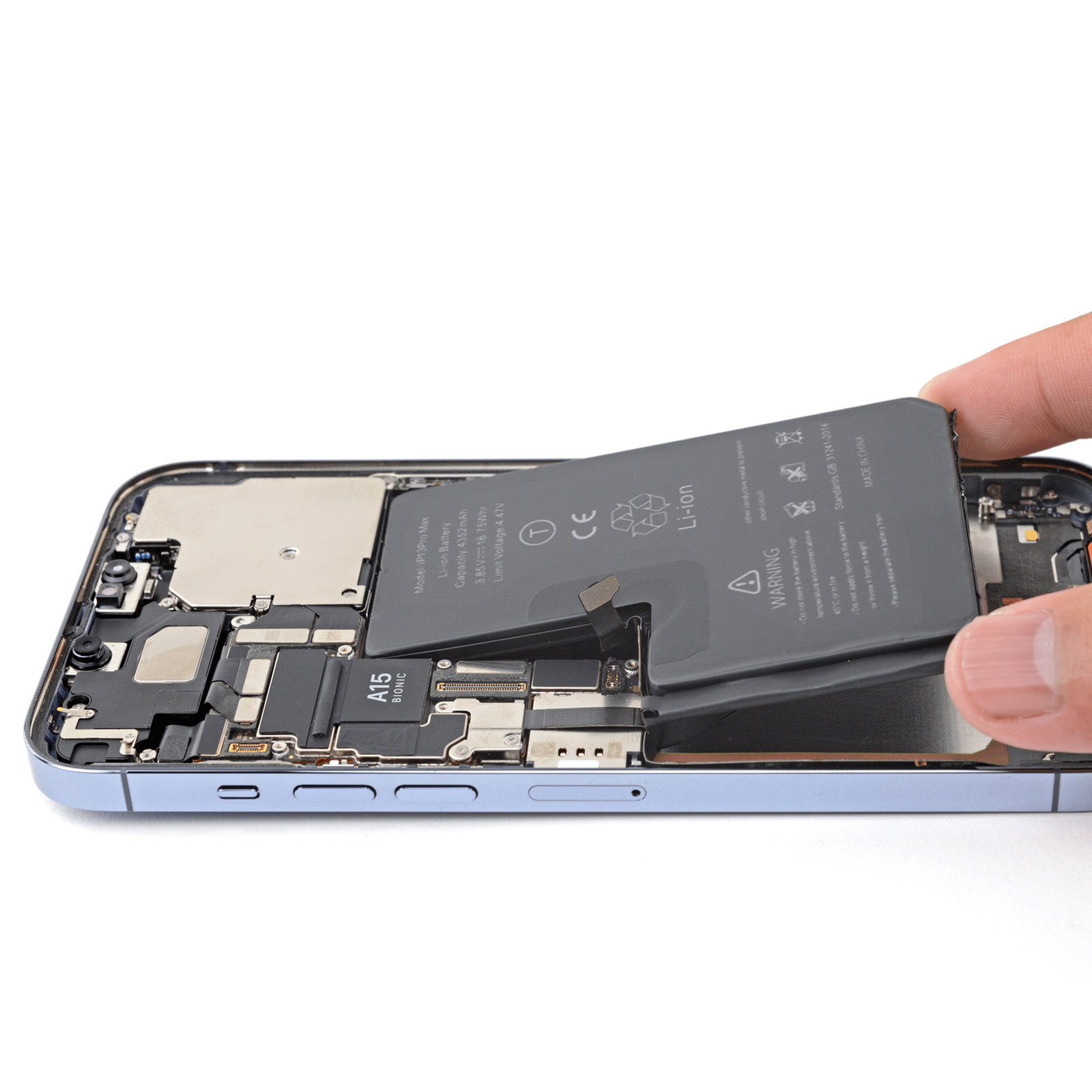 Un telefono con componenti visibili e una batteria rimossa da una mano.