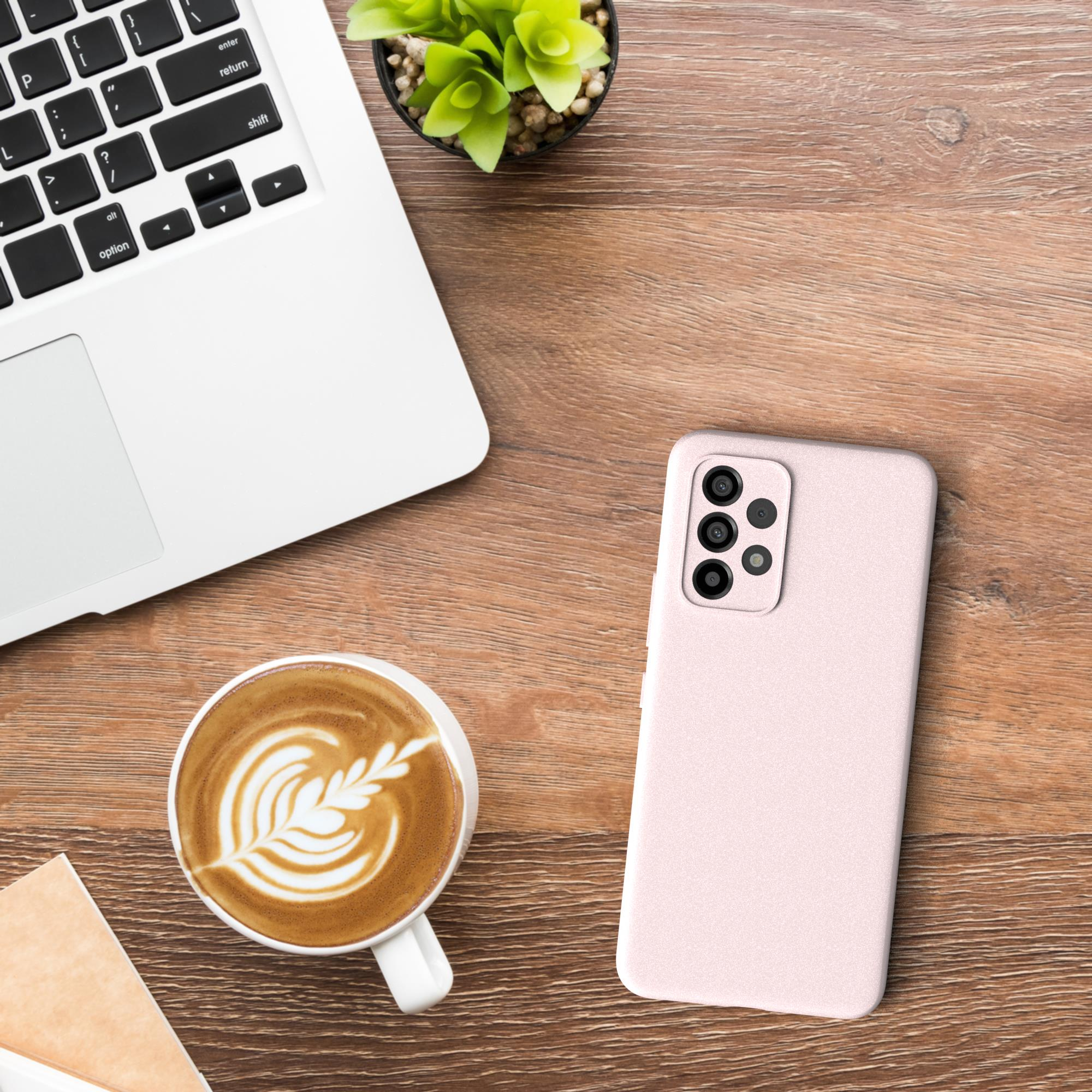 Ein Laptop, eine Tasse Kaffee mit Latte Art und eine Handyhülle auf einem Holzschreibtisch.