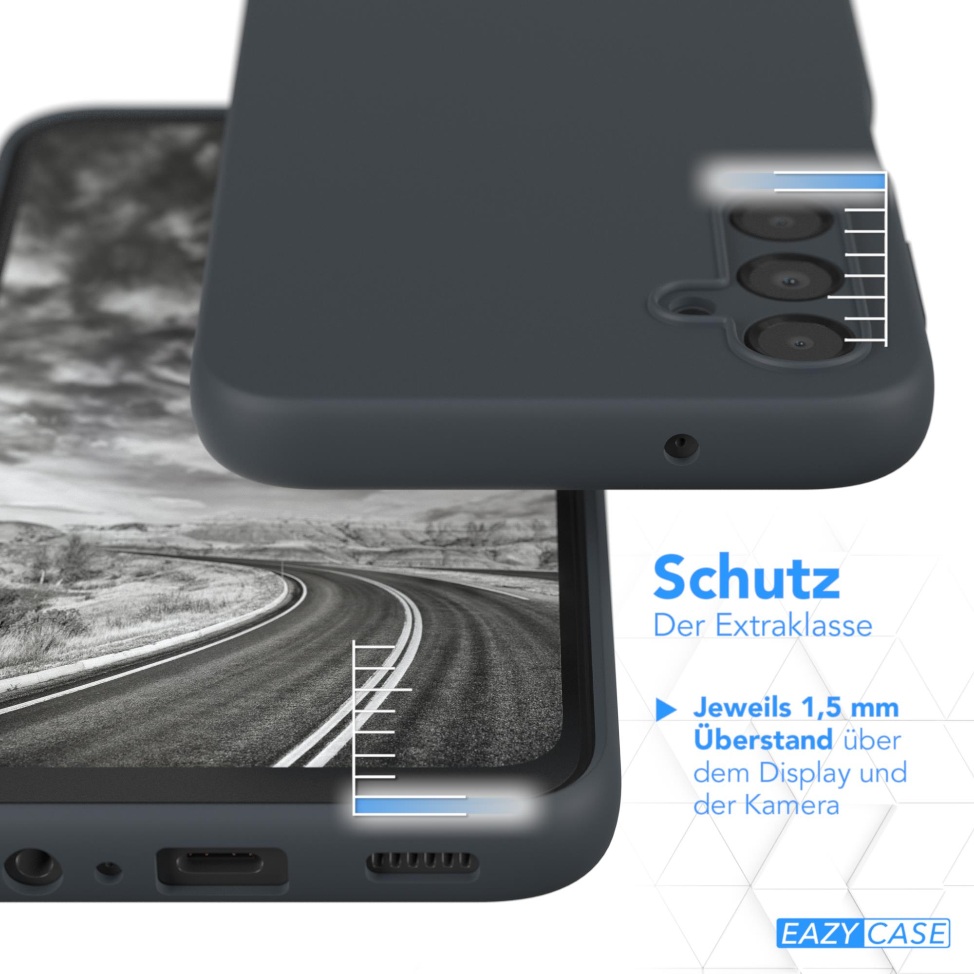 Ein Telefon in einer dunkelgrauen Hülle. Das Telefon ist nah an einem Straßenbild.
