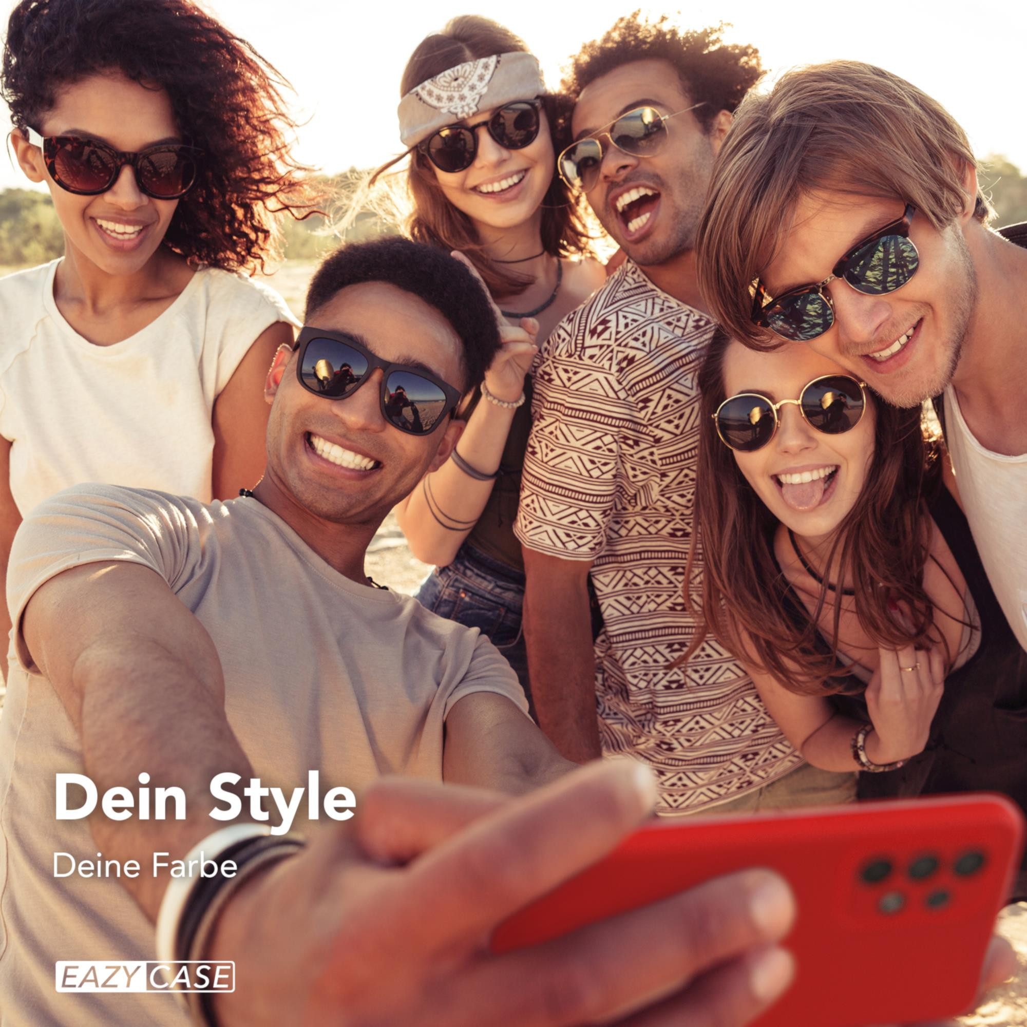 Eine Gruppe lächelnder Leute macht ein Selfie mit einem roten Telefon.