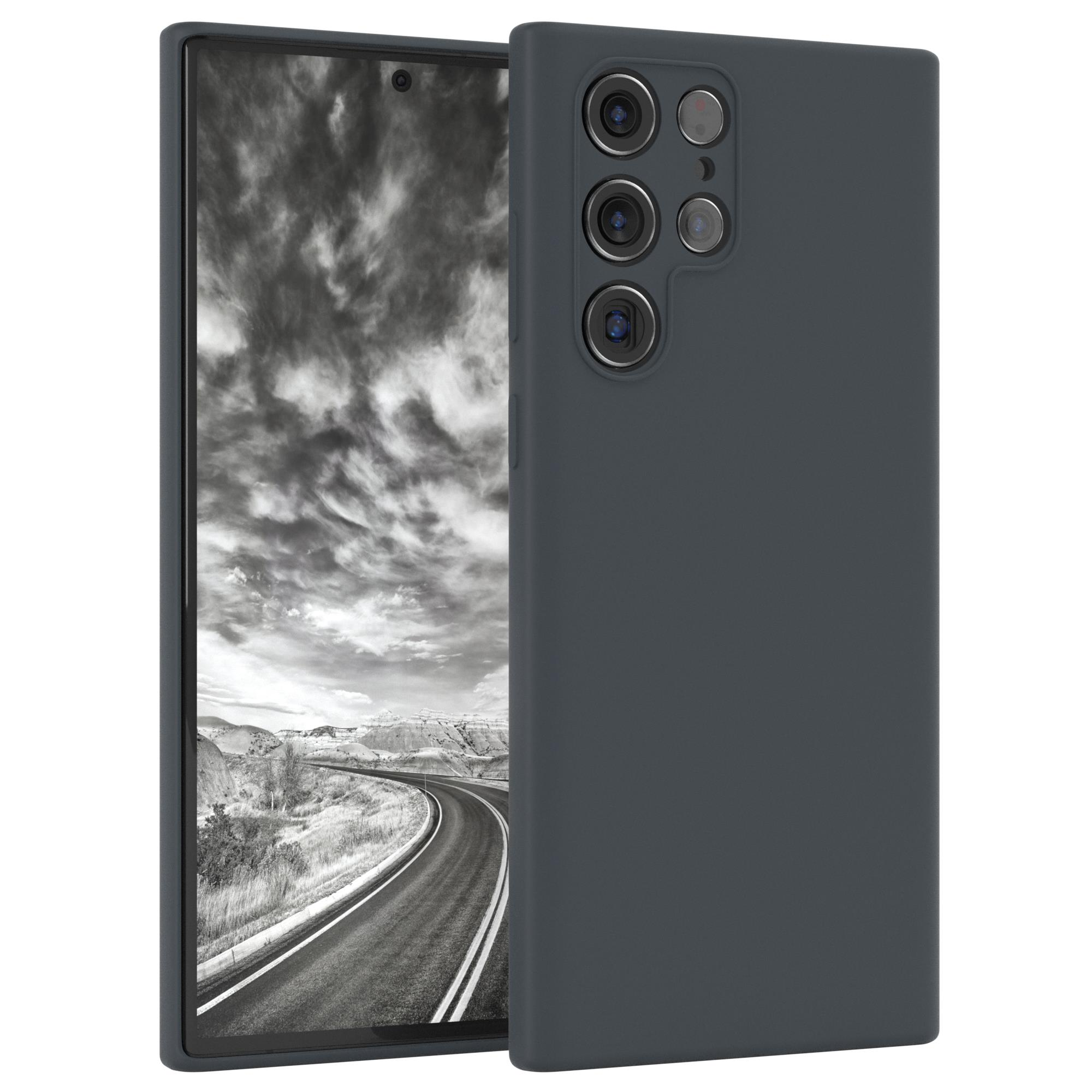 Dunkelgraue Handyhülle mit einem Telefon darin. Der Hintergrund ist eine Graustufenlandschaft.