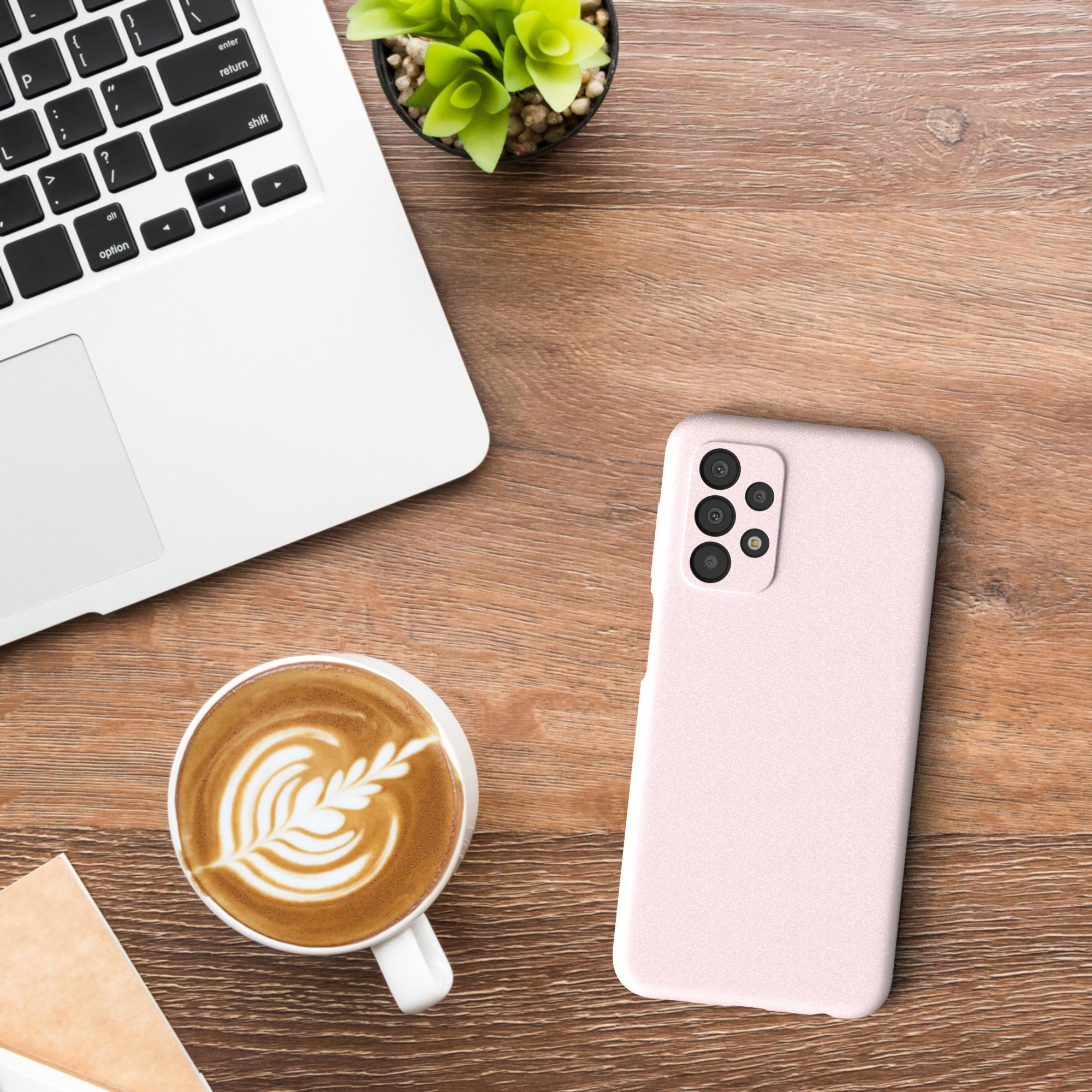 Holzschreibtisch. Laptop, Kaffee, Telefon und Pflanze sind angeordnet. Kaffee hat Latte Art.