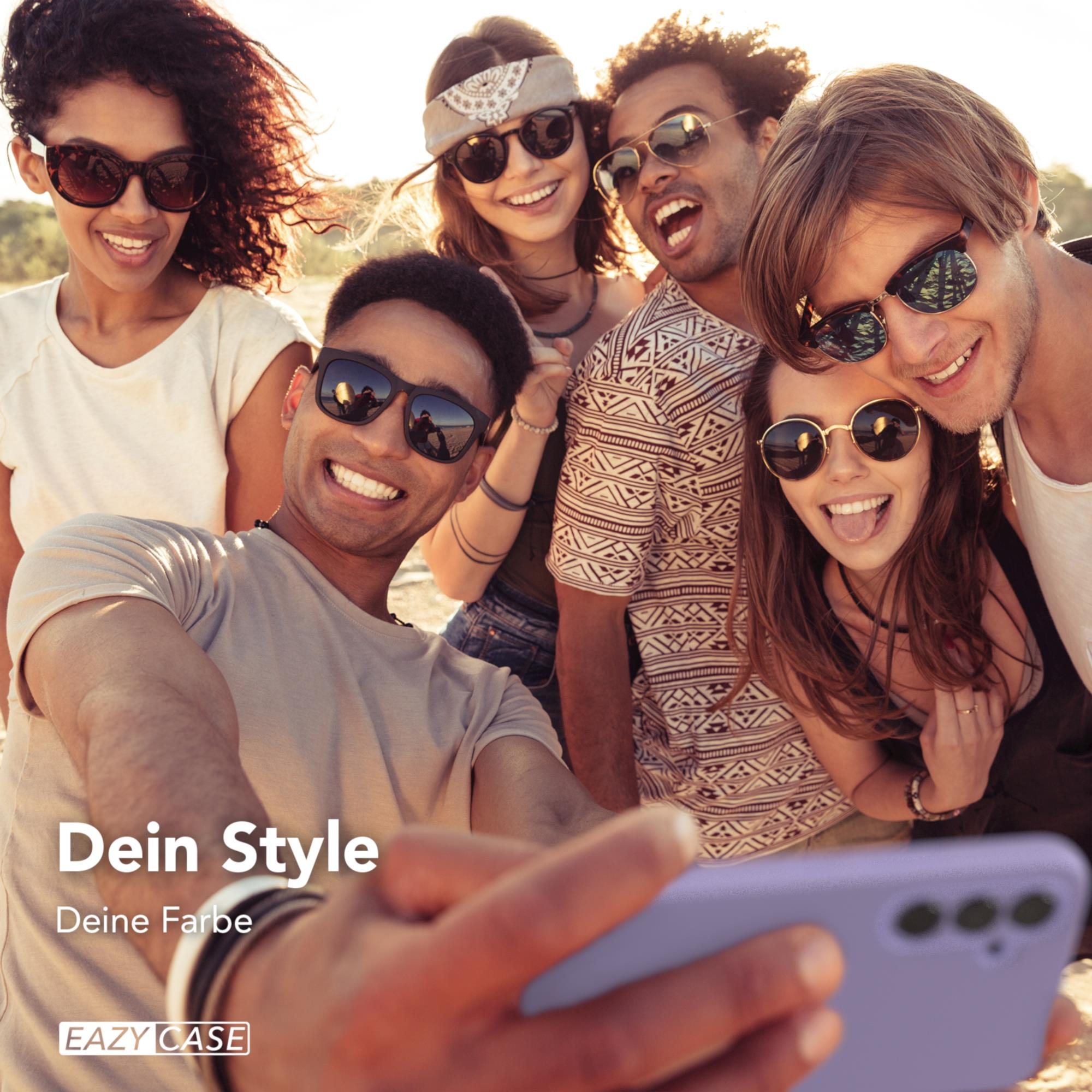 Sechs Personen am Strand, die ein Selfie mit einem lila Telefon machen.