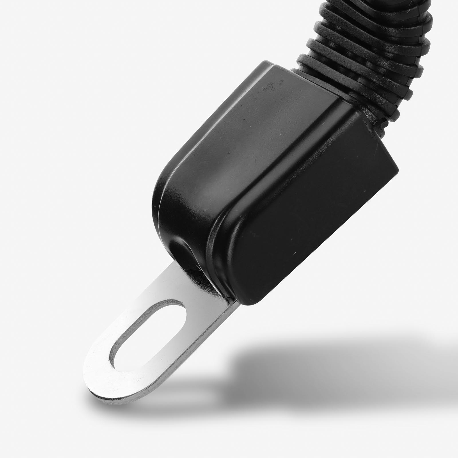 Primo piano di una fibbia della cintura di sicurezza nera con linguetta di metallo. Lo sfondo è bianco.