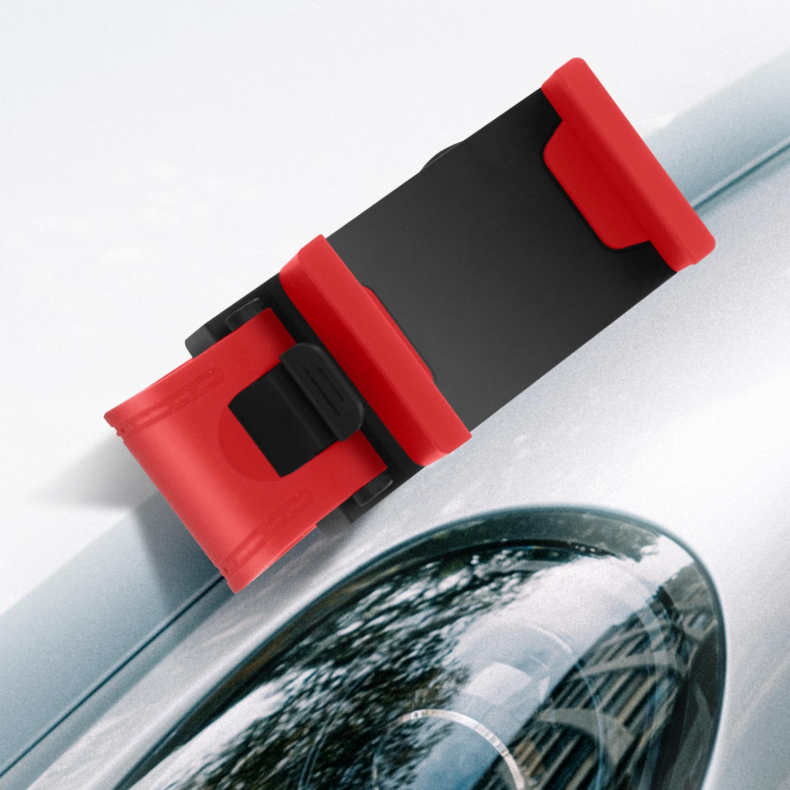 Soporte para teléfono rojo y negro en un coche. El soporte está en el capó del coche.
