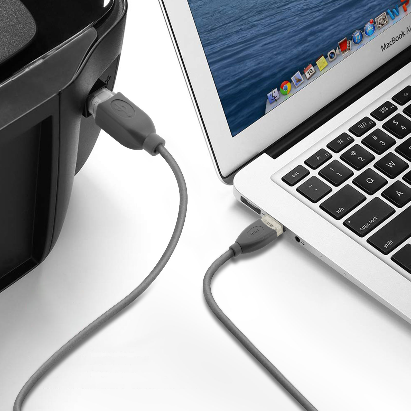 Cavo USB collegato a una stampante e a un laptop. L'installazione è su una superficie bianca.