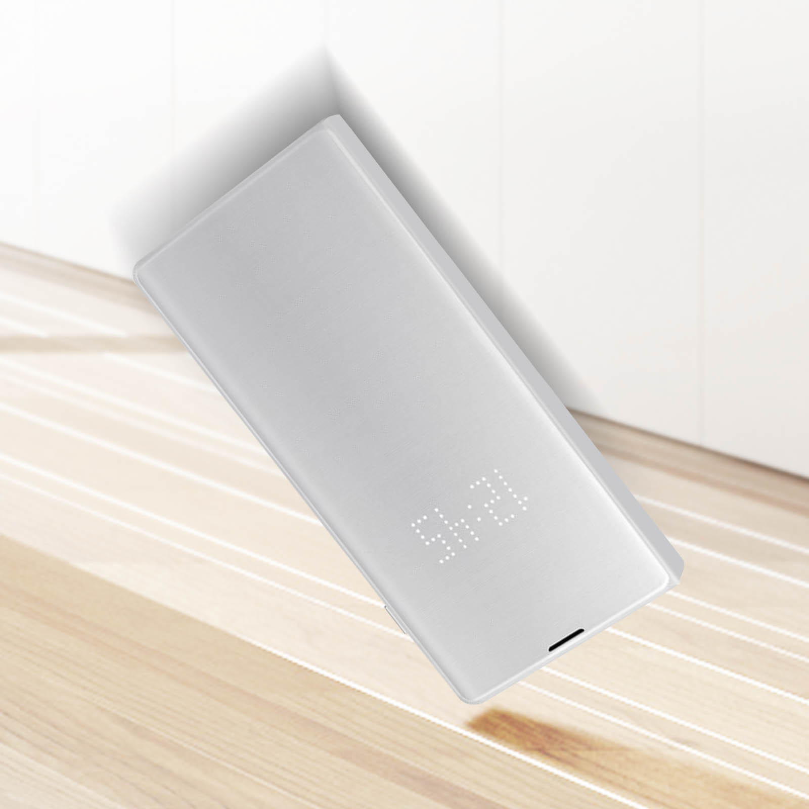 Una funda blanca para teléfono con pantalla digital que muestra 09:49, sobre superficie madera.