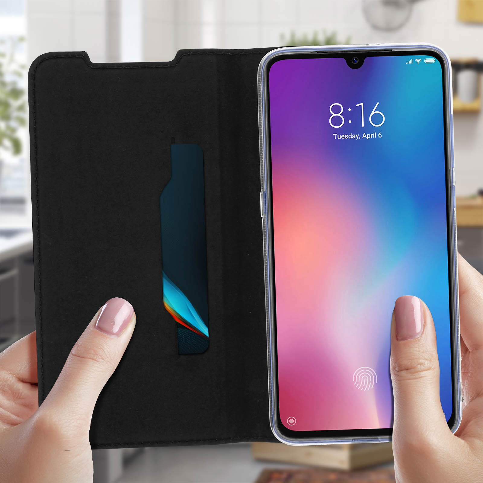 Una persona tiene aperta una custodia nera per telefono, che rivela uno slot per carte. Lo schermo mostra l'ora e la data.