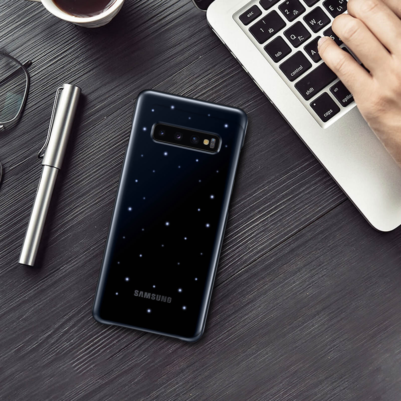 Eine schwarze Samsung-Handyhülle mit Sternendesign auf einem Holztisch.
