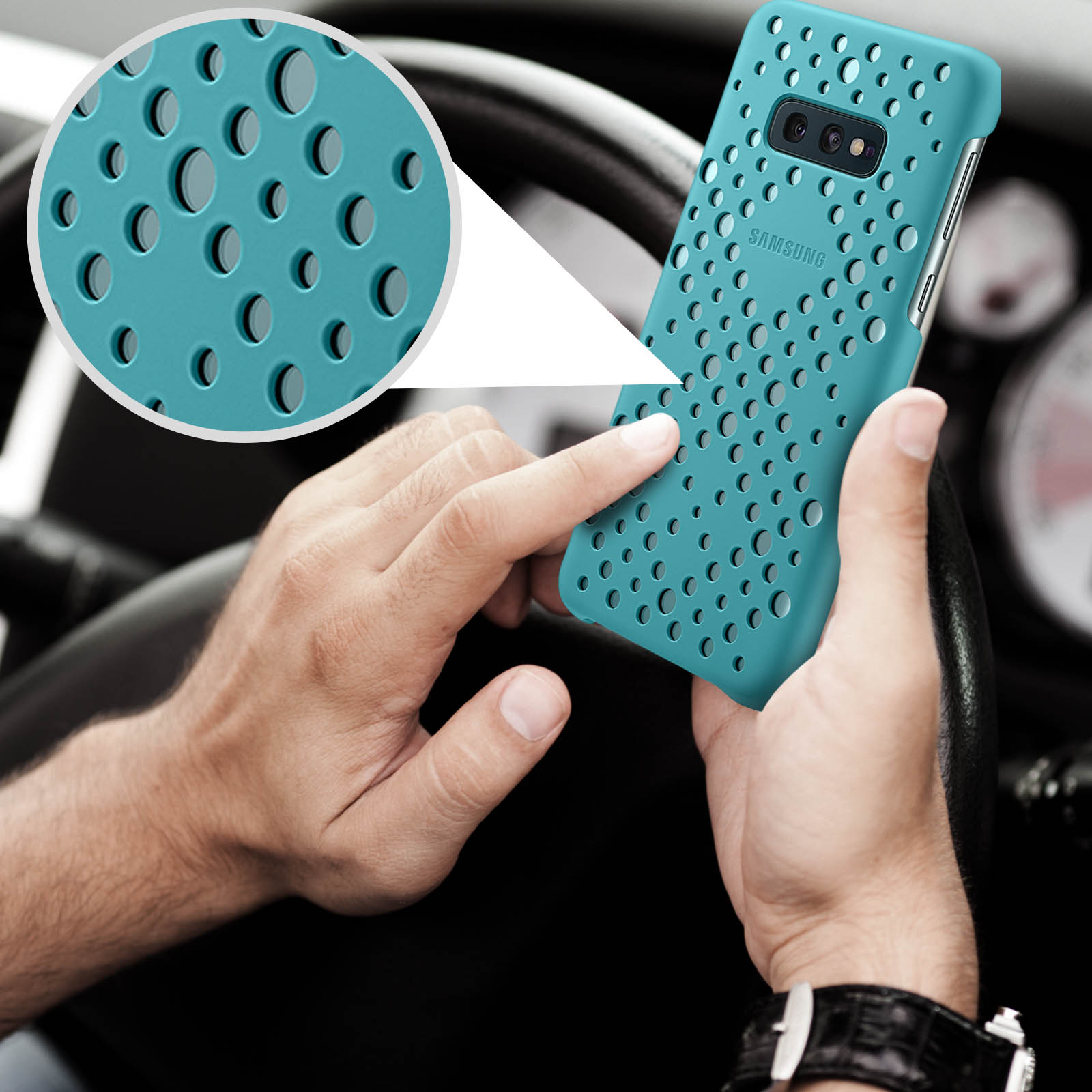 Main tenant une coque de téléphone turquoise avec des trous circulaires. Intérieur de voiture en arrière-plan.
