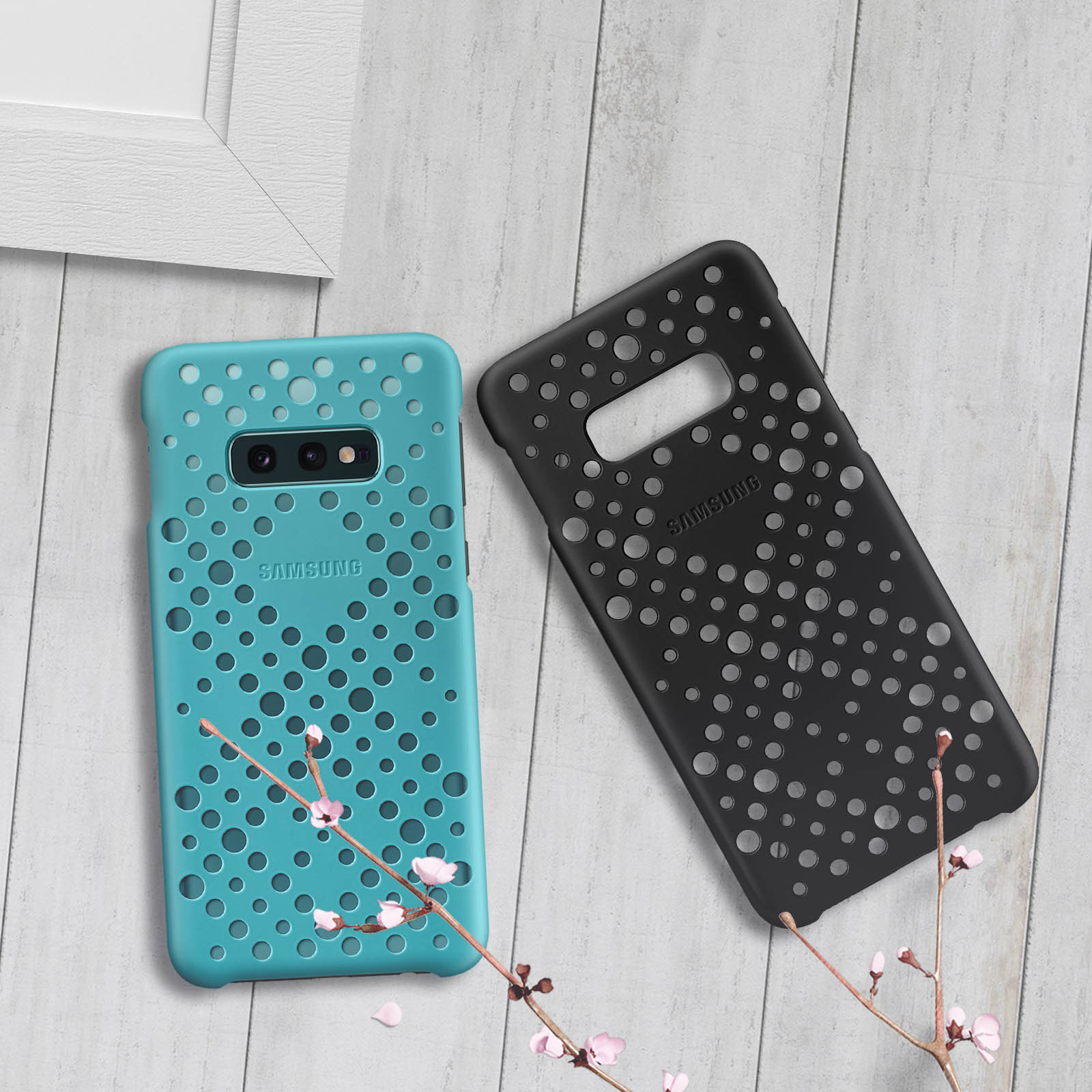 Coques de téléphone turquoise et noires. Les coques ont un design pointillé, placées sur une surface en bois.
