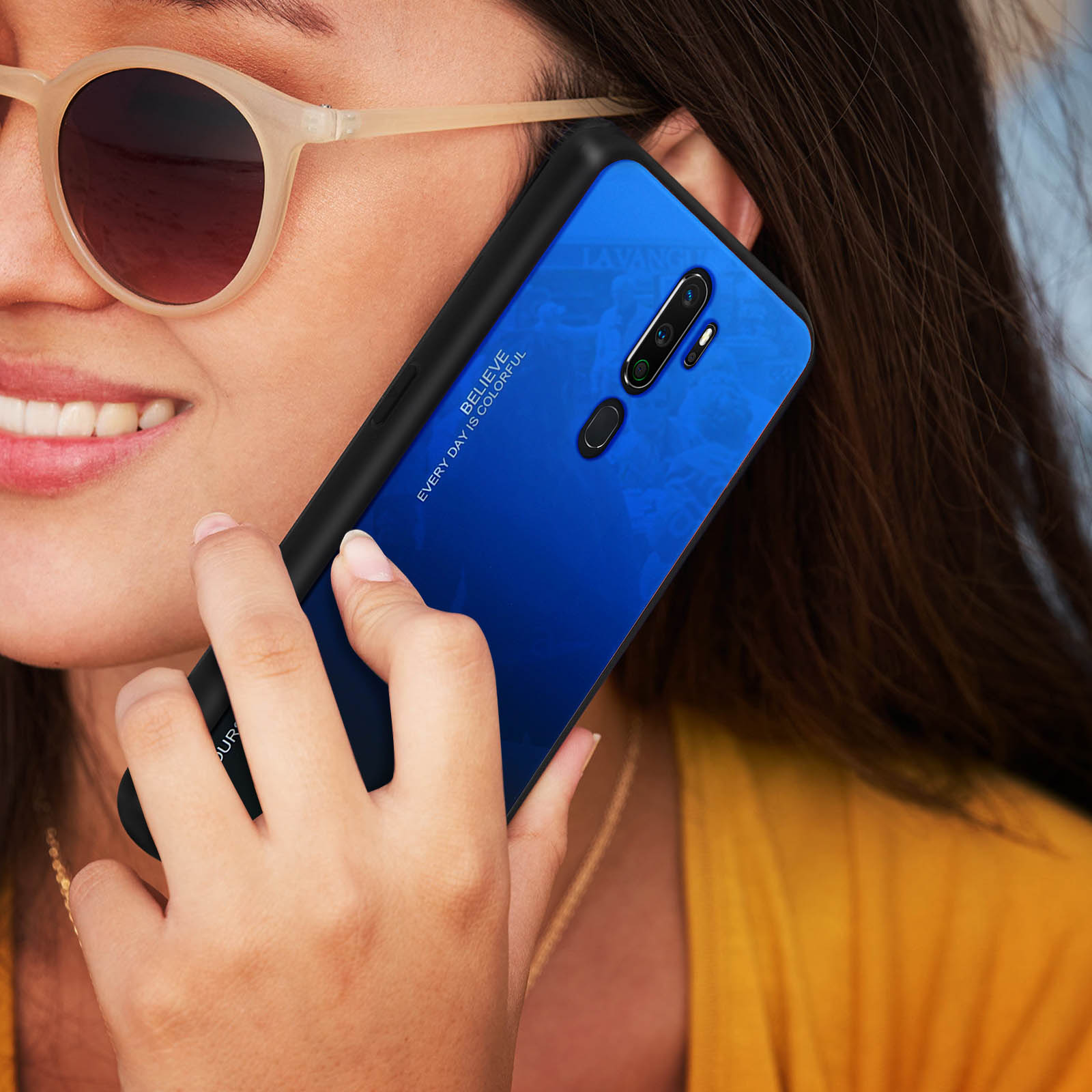Frau hält Telefon mit blauer/schwarzer Hülle. Sie trägt Sonnenbrille.