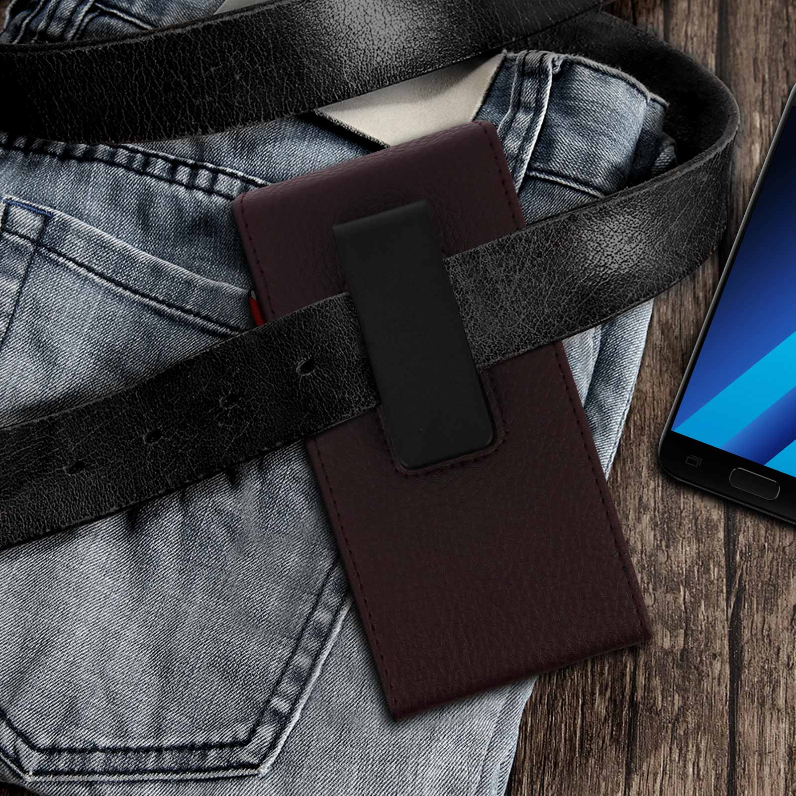 Telefon in brauner Leder-Gürtelclip-Tasche, auf Holzoberfläche, in der Nähe Jeans.