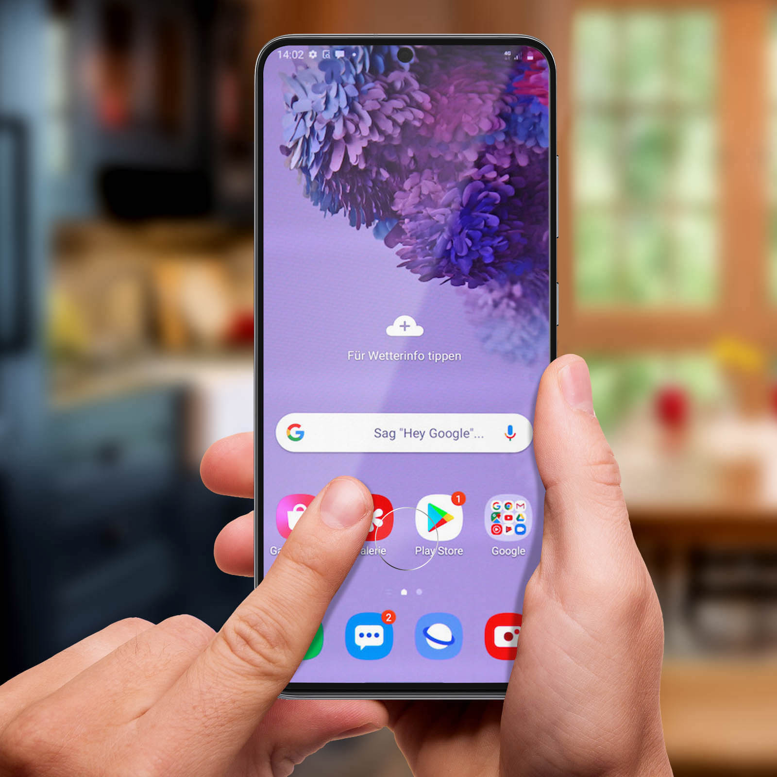 Mano che tiene un telefono con sfondo floreale viola. Lo schermo mostra icone di app, un dito tocca l'icona Galleria.