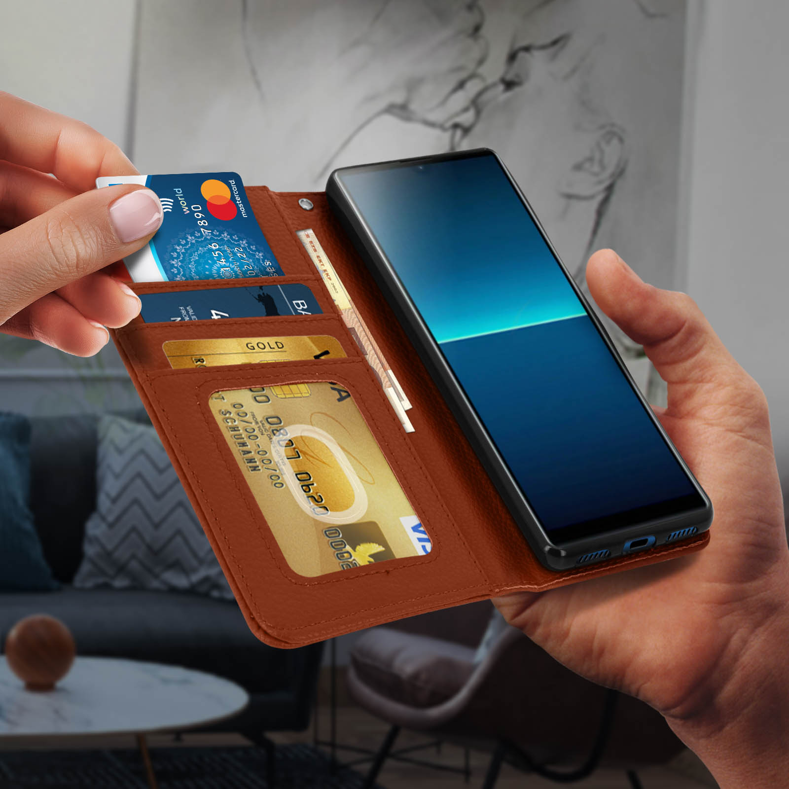 Una mano inserisce una carta in un portafoglio che tiene un telefono. Carte, contanti e telefono visibili.