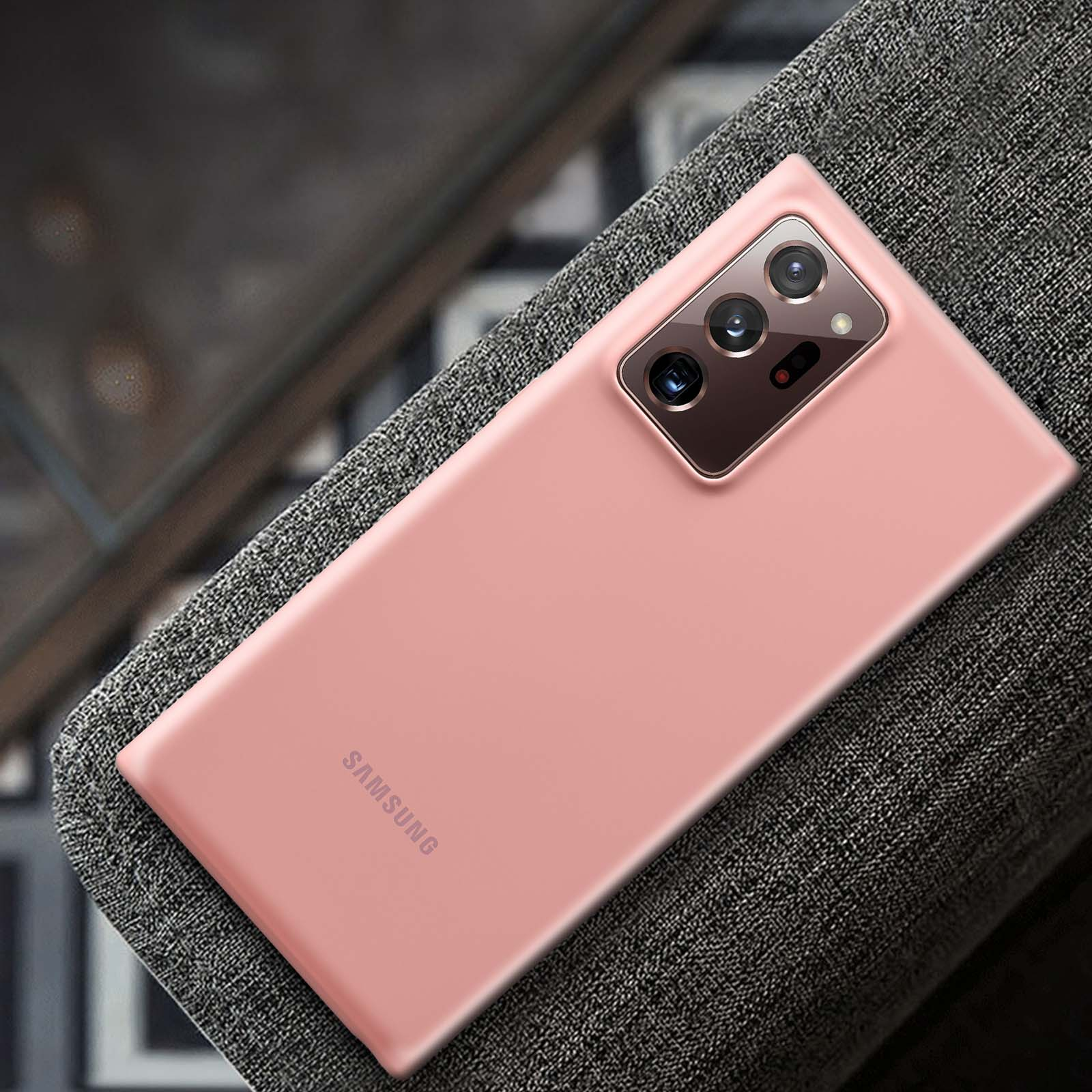 Una custodia per telefono Samsung rosa su una superficie grigia strutturata, che mostra l'area della fotocamera.