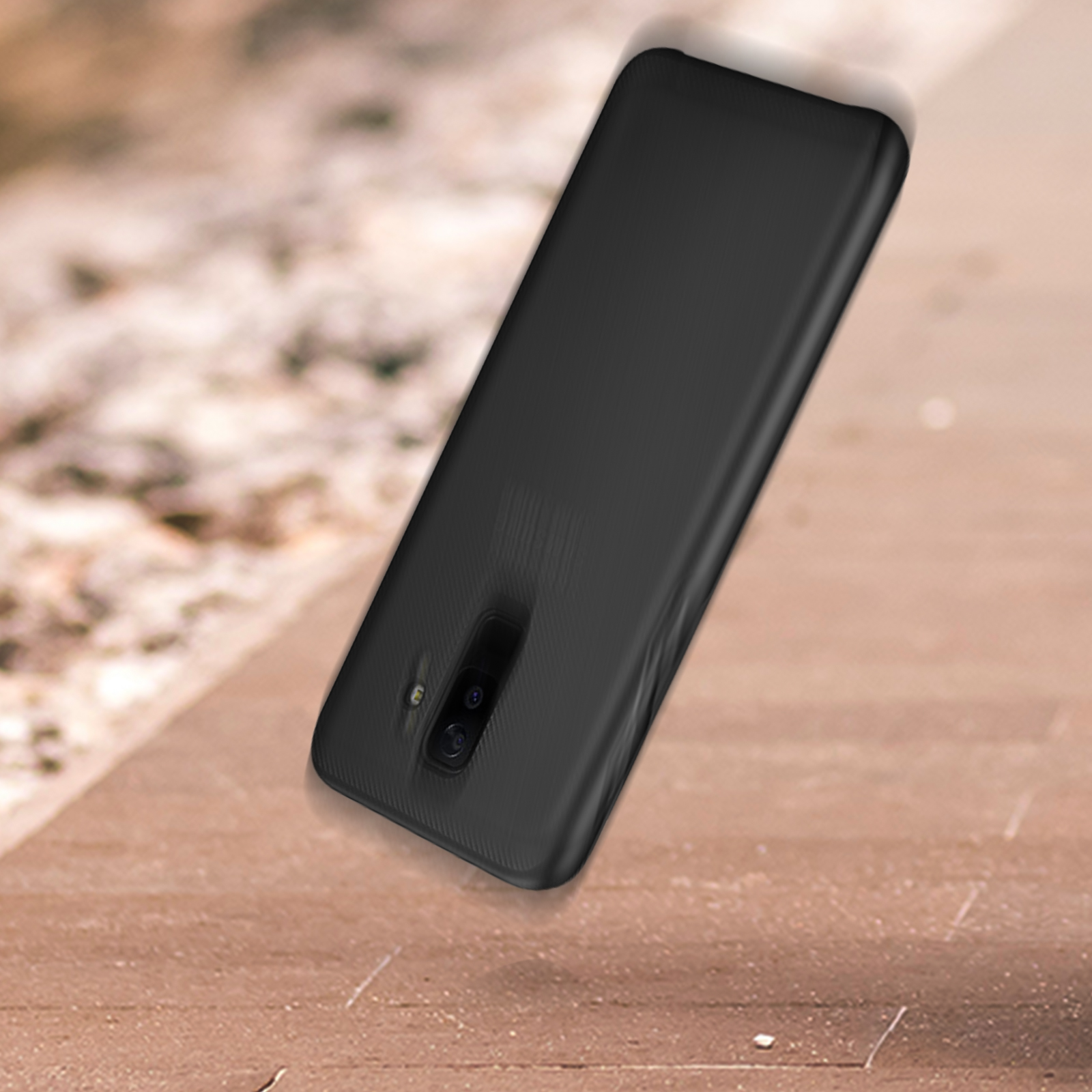 Una custodia nera per telefono su una superficie di legno. La custodia ha un ritaglio per la fotocamera e un retro strutturato.