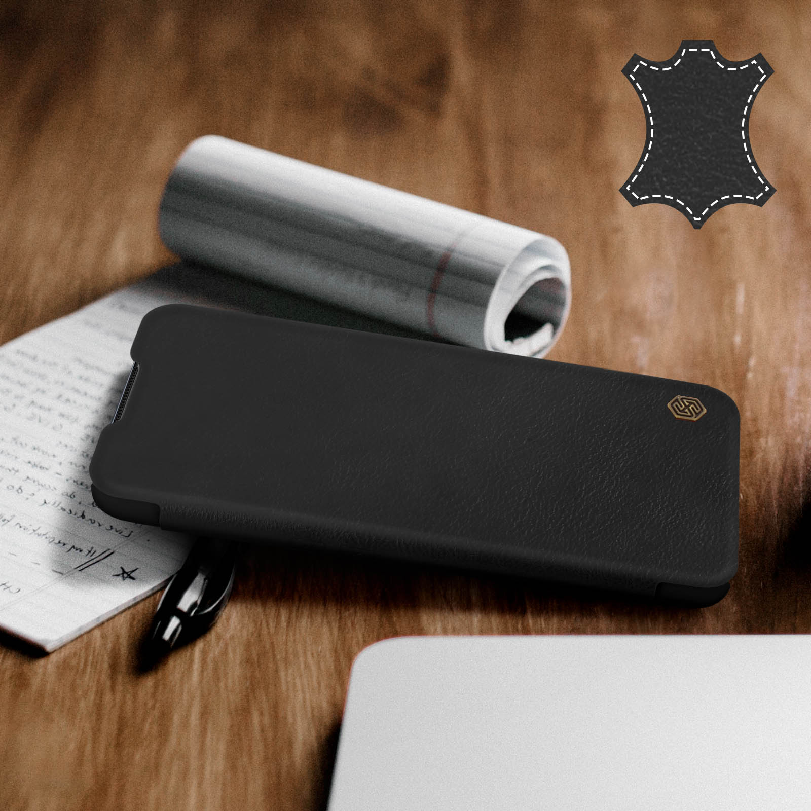 Schwarze Handyhülle mit Stift und Notizen auf Holzoberfläche, zeigt Lederstruktur, Nahaufnahme.