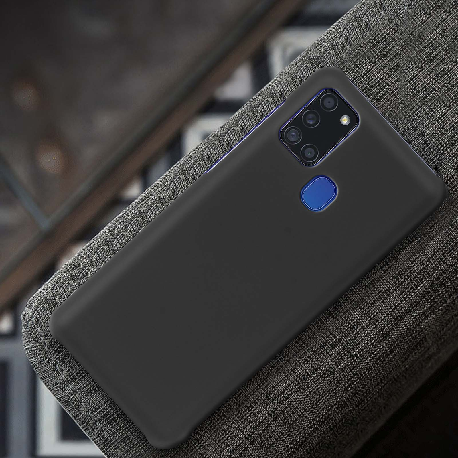 Una custodia nera per telefono su una superficie grigia strutturata, con modulo fotocamera scuro.