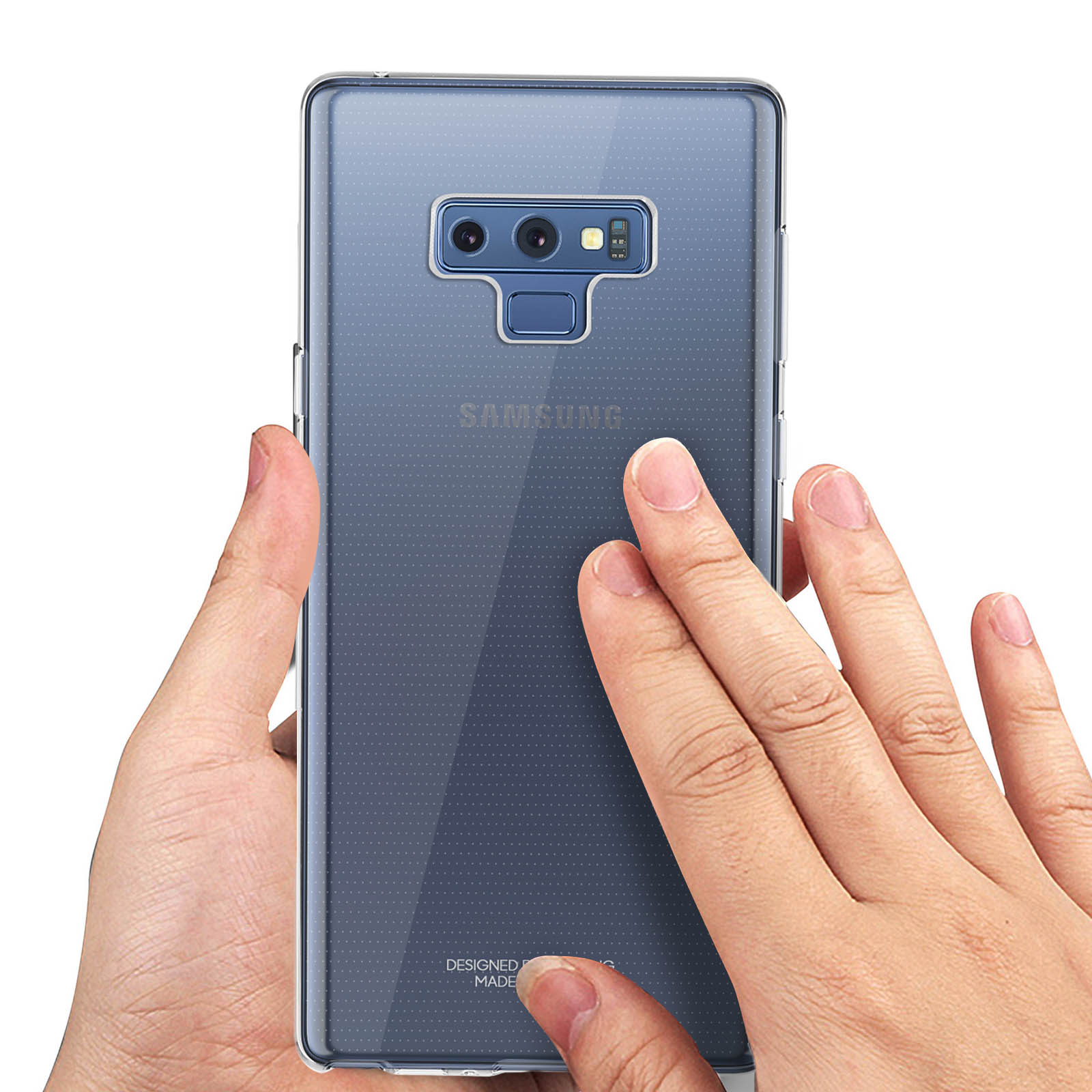 Mains tenant une coque de téléphone transparente. Le logo Samsung est visible. Fond sombre.