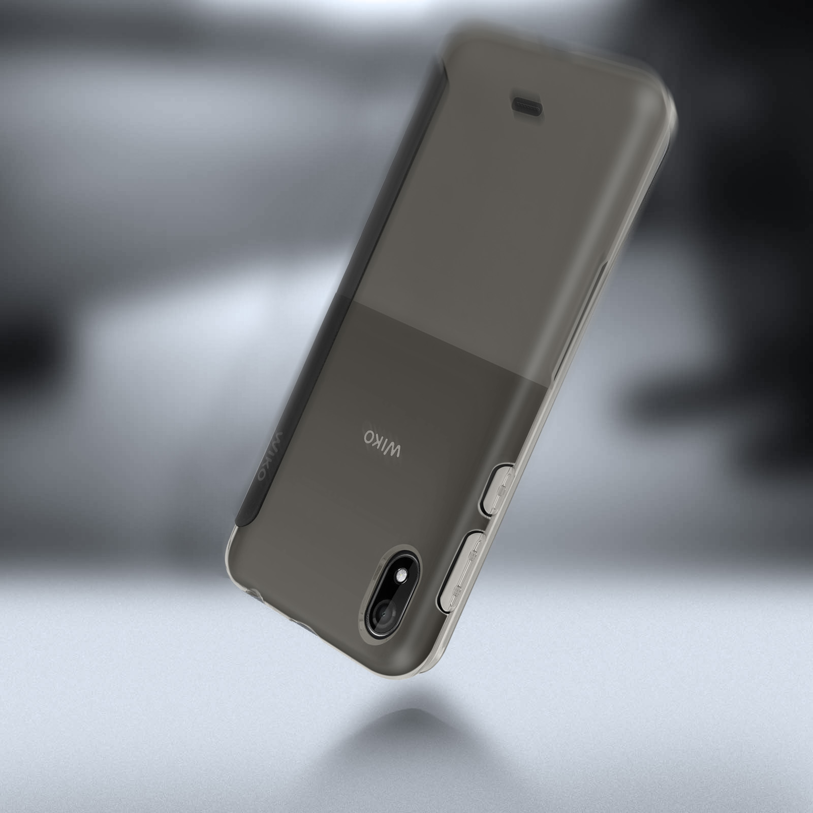 Custodia per telefono Wiko. Grigio scuro, design bicolore. Logo Wiko sul lato. Sfondo sfocato.