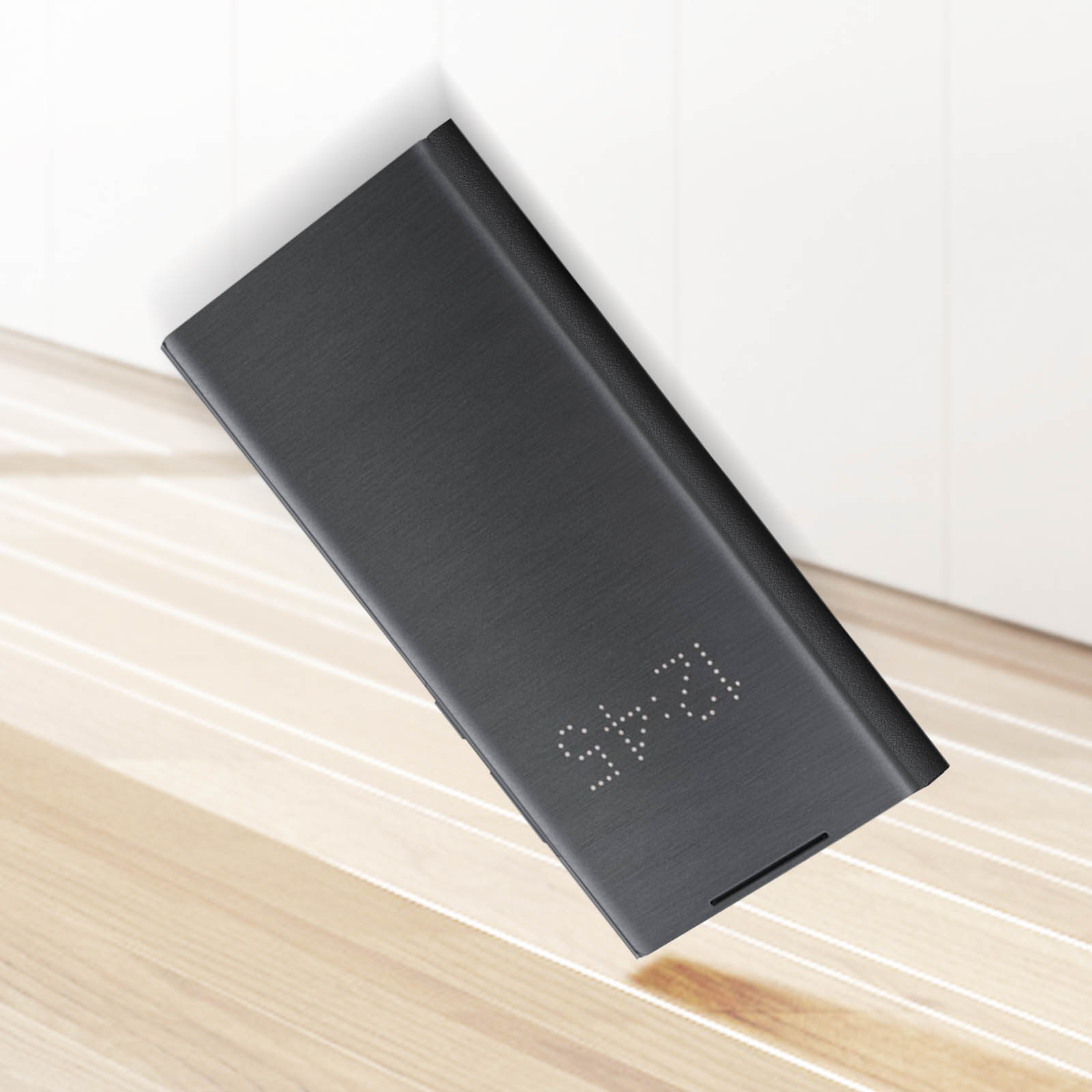 Czarne etui na telefon z wyświetlaczem czasu i drewnianym tłem. Godzina to 12:45.