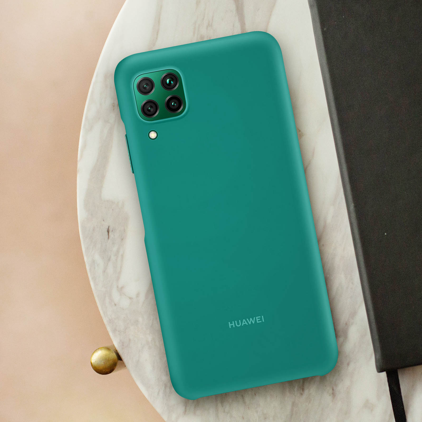 Una custodia per telefono verde acqua su una superficie di marmo, con la scritta 'HUAWEI'.