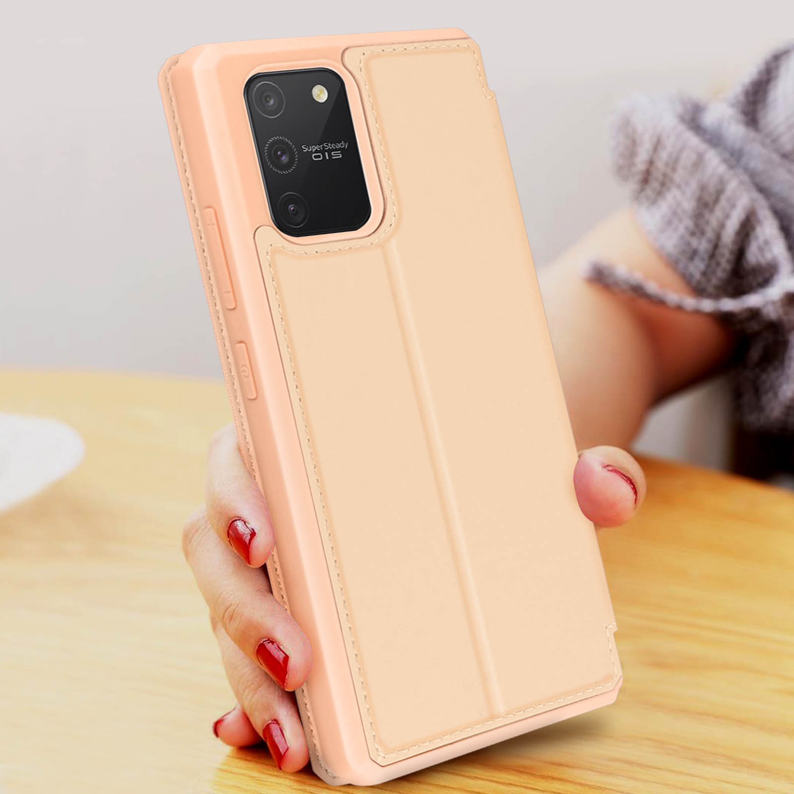 Telefono in una custodia rosa tenuto da una persona. La custodia è piegata e in piedi.